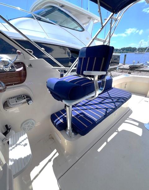 2004 Mainship 30 Pilot Rum Runner boat with blue seating, docked by the water.