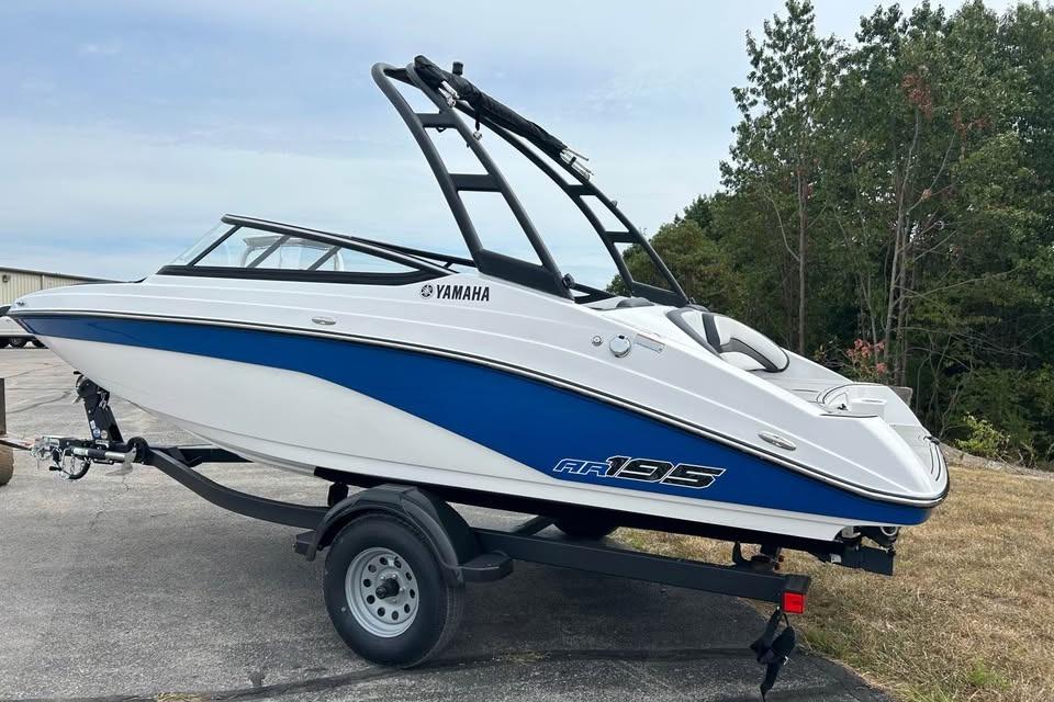 2026 Yamaha AR195 boat on trailer, blue and white design, parked outdoors.