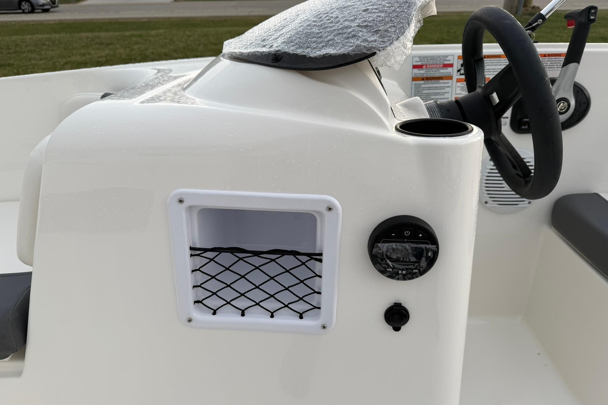 2026 Bayliner Element E16 boat dashboard with steering wheel and storage compartment.