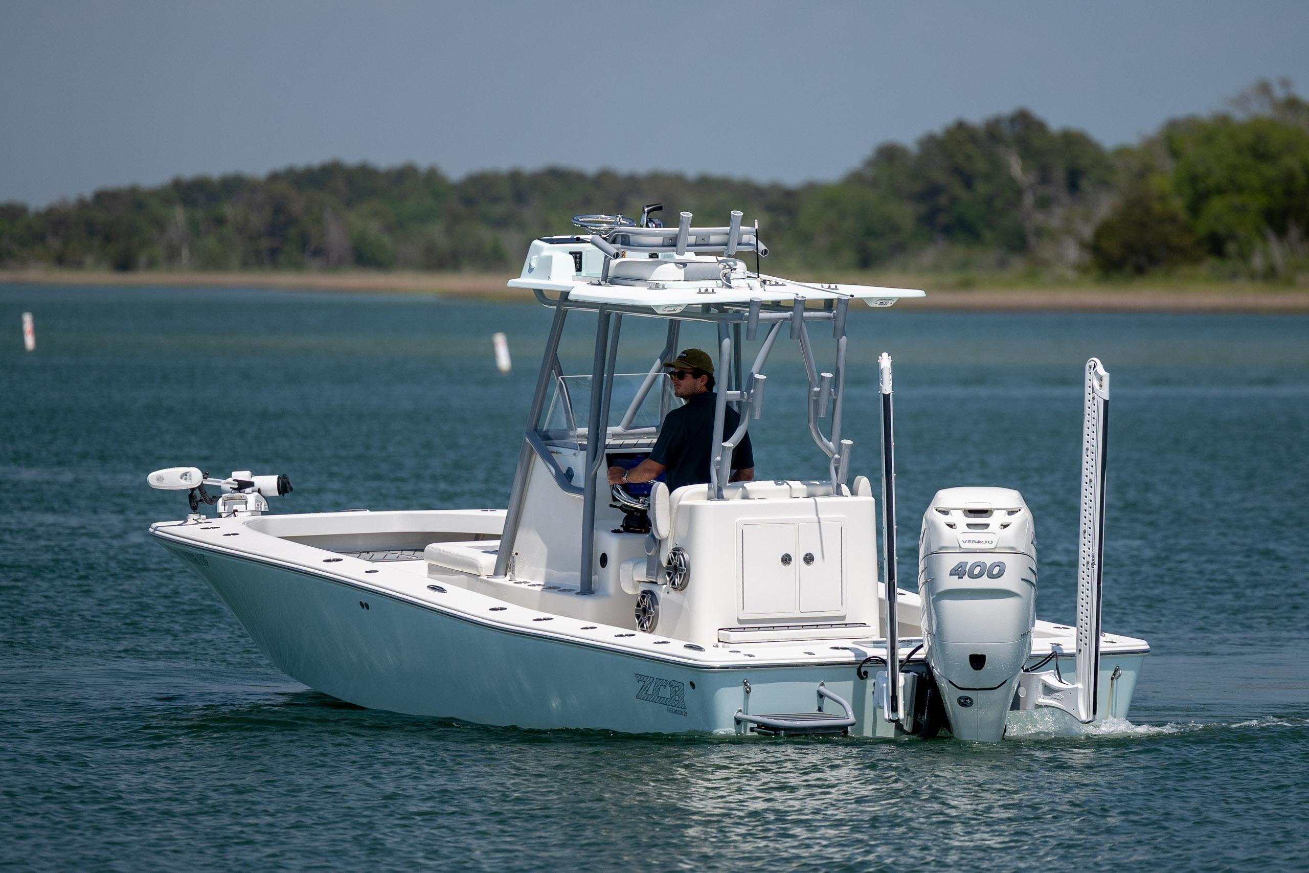 A 2022 ZCB Freemason 26 boat cruising on a calm lake with a person onboard.