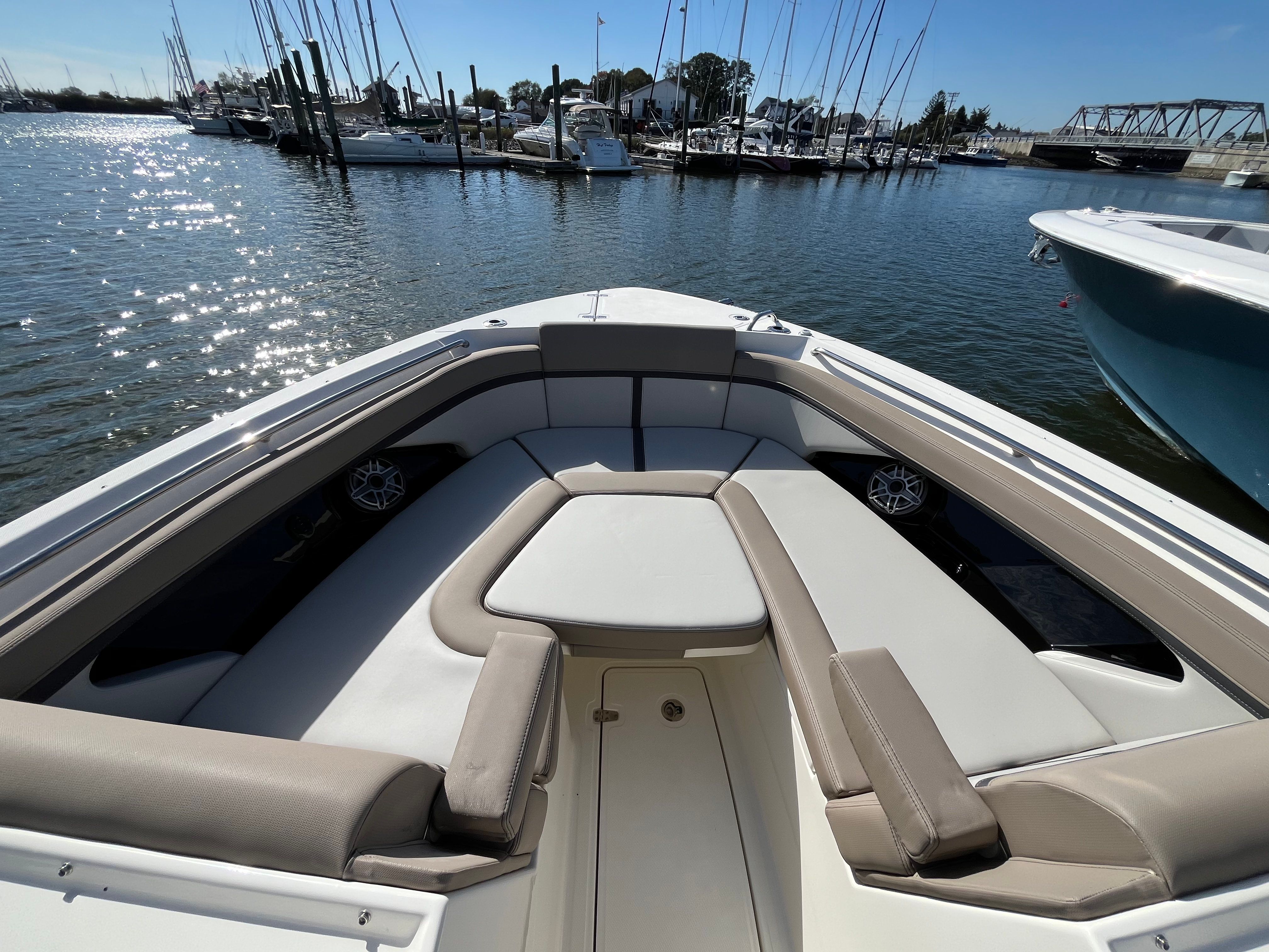 The image shows the bow seating area of a Boston Whaler 330 Vantage boat in a marina.