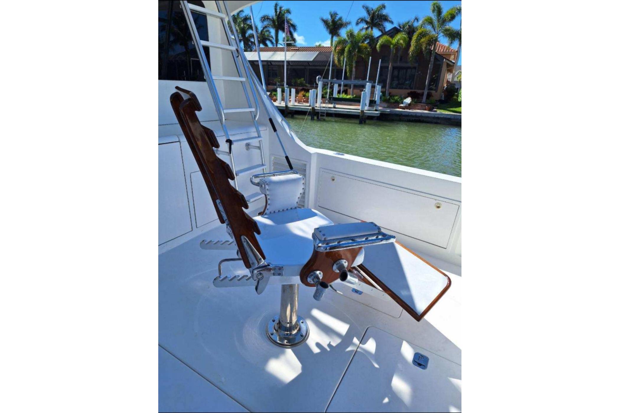 Fishing chair on 2001 Cavileer 53 Convertible yacht, docked near palm trees.