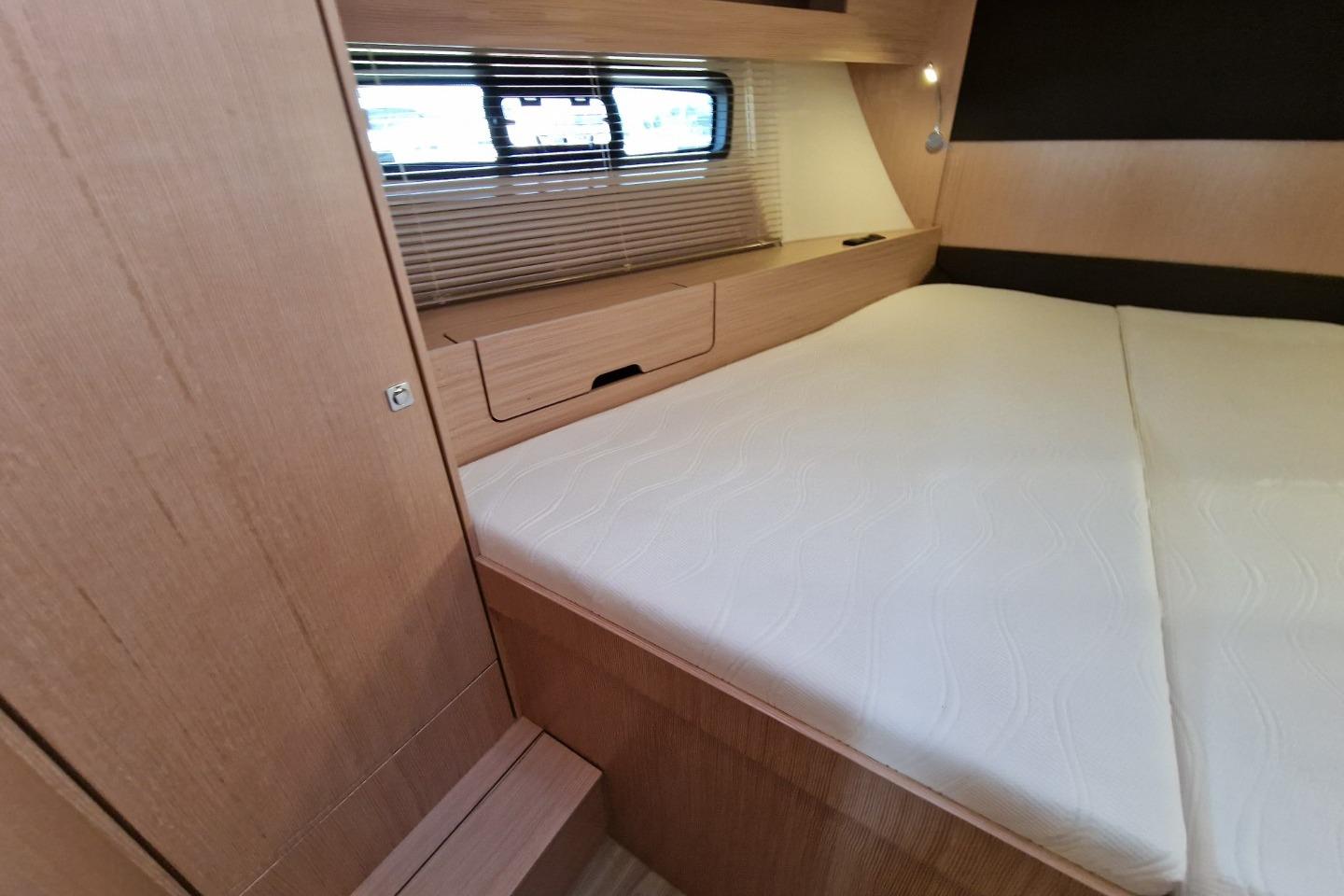 2023 Bavaria SR41 yacht interior cabin with wooden finish and comfortable bedding.