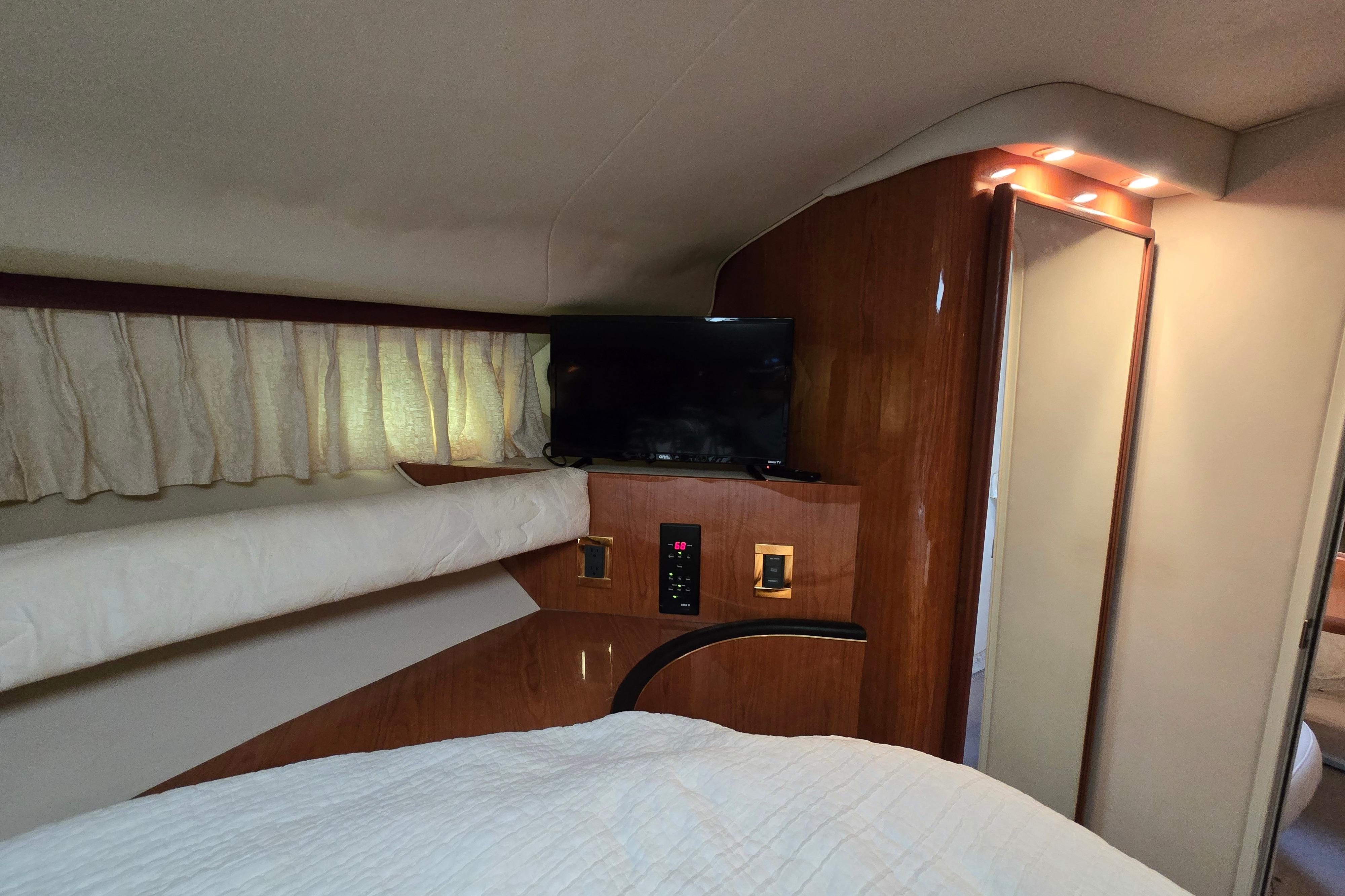 Interior cabin of 1999 Sea Ray Sundancer 400 with TV and wood paneling.
