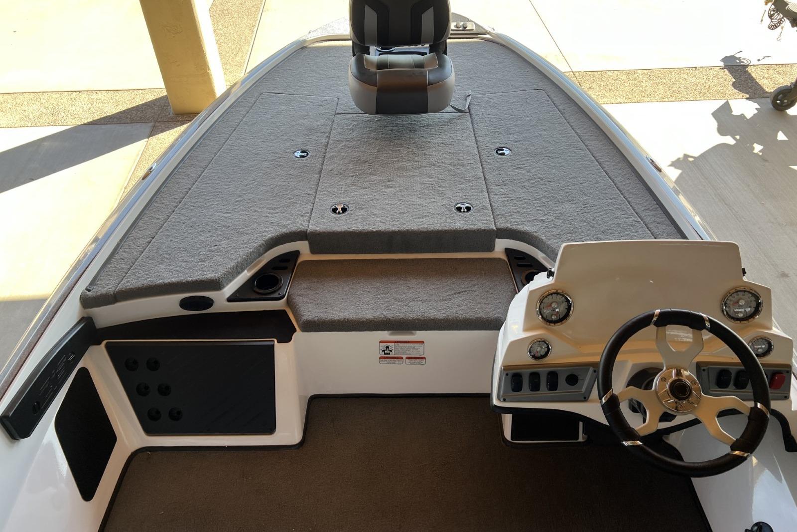 2025 Nitro Z19 boat interior with steering wheel and carpeted deck.