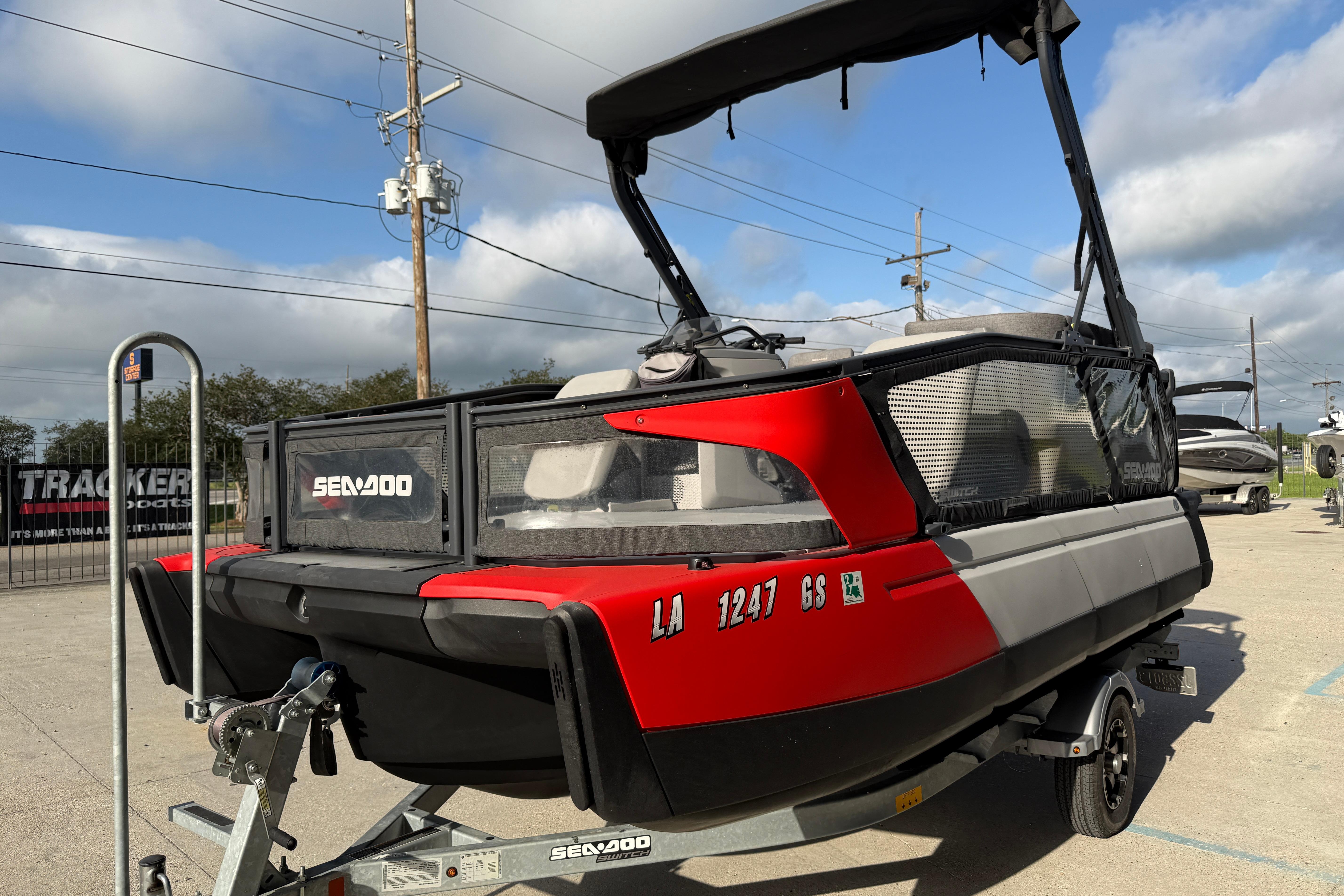 2023 Sea-Doo Switch Sport 18 pontoon boat on trailer, parked outdoors.