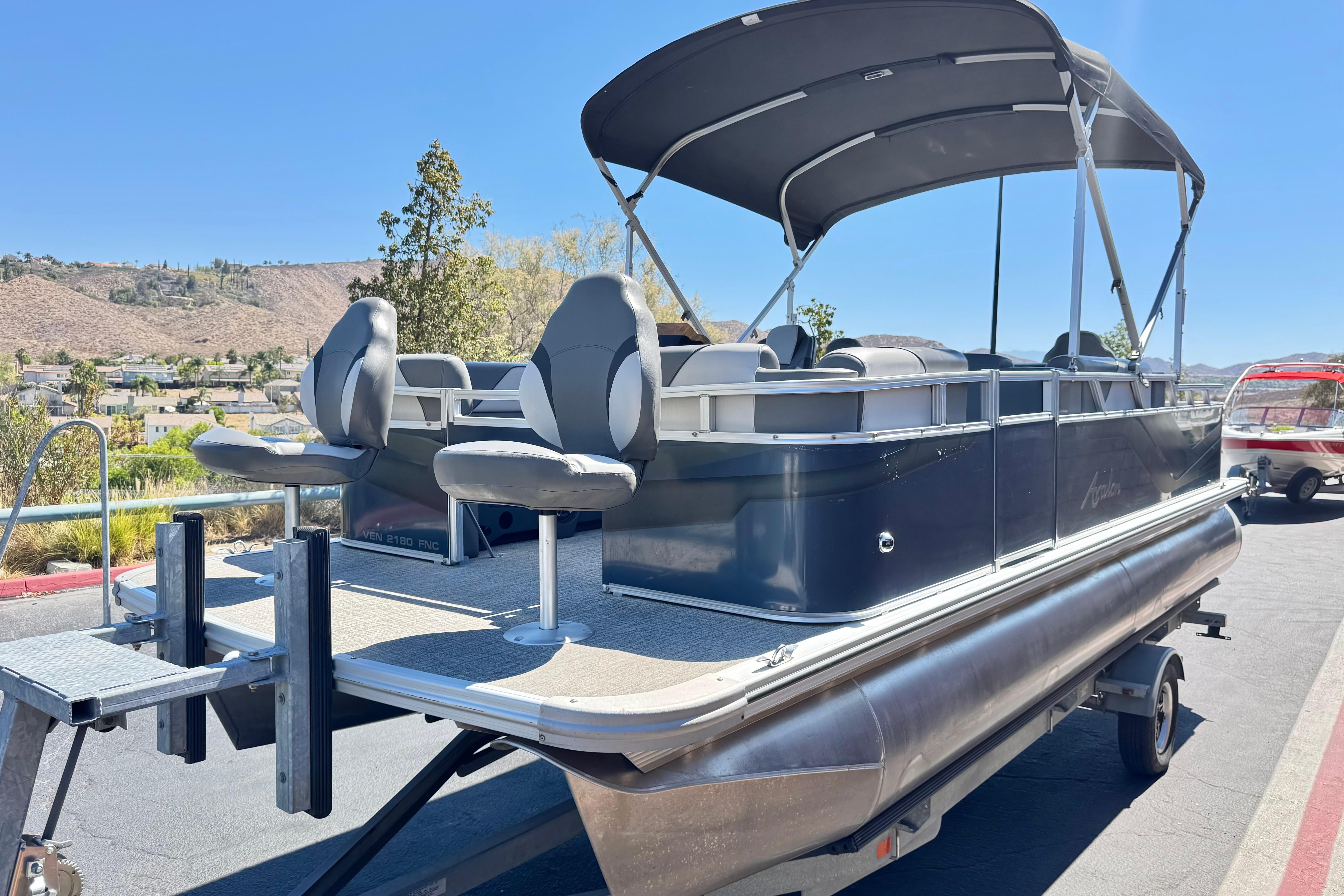 2023 Avalon Venture Fish N Cruise 20' pontoon boat with canopy, parked outdoors.