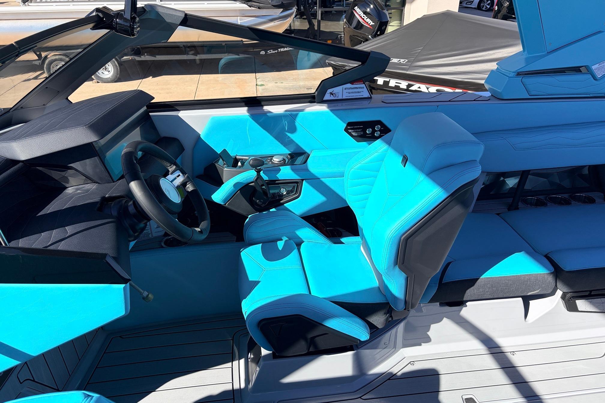 Interior of 2026 Nautique Super Air Nautique G23 with vibrant blue seating and modern controls.
