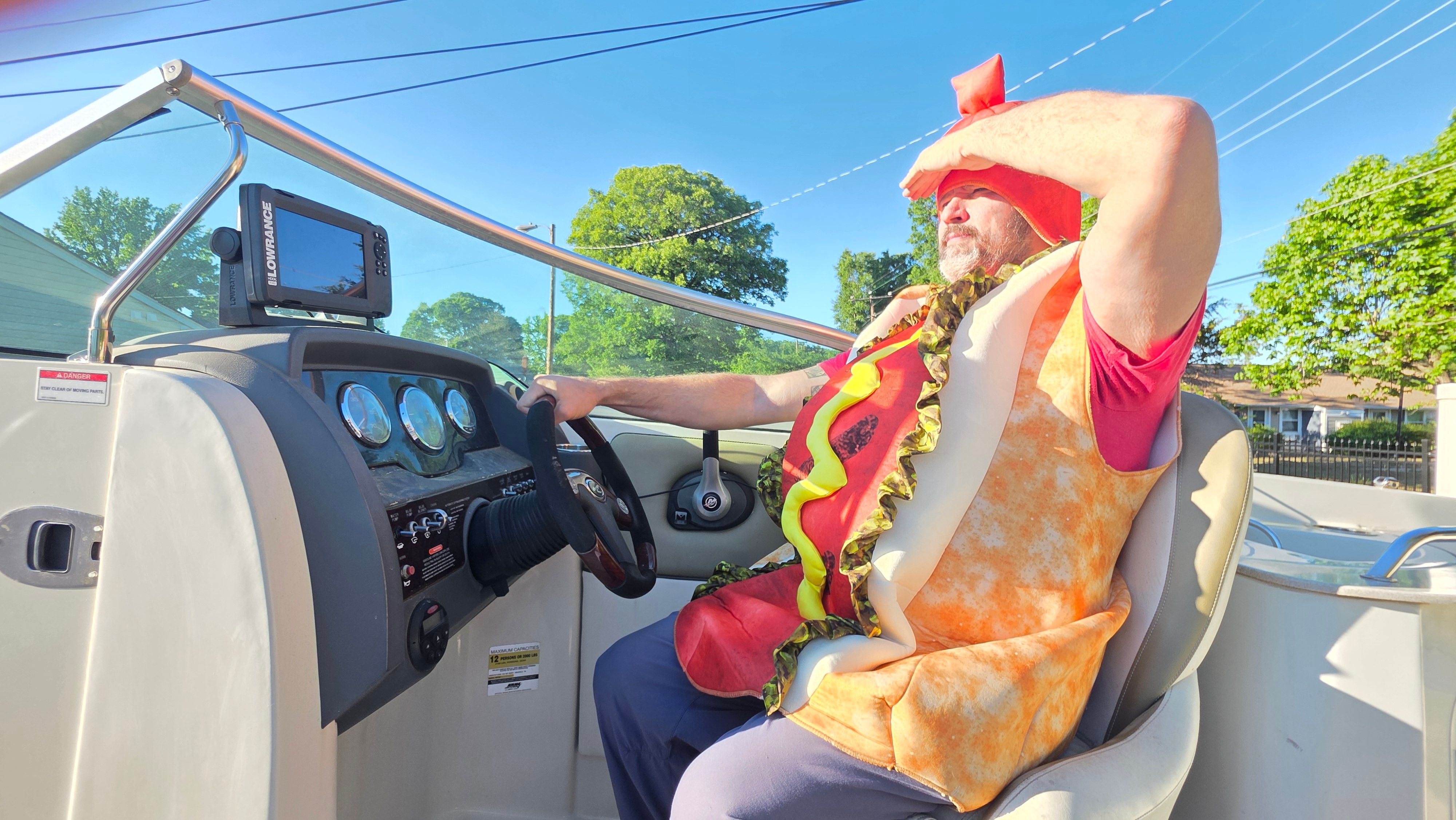 Man in hotdog costume steering 2007 Sea Ray 260 Sundeck boat.