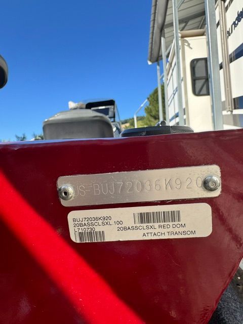 Close-up of a red boat hull with serial number and sticker.