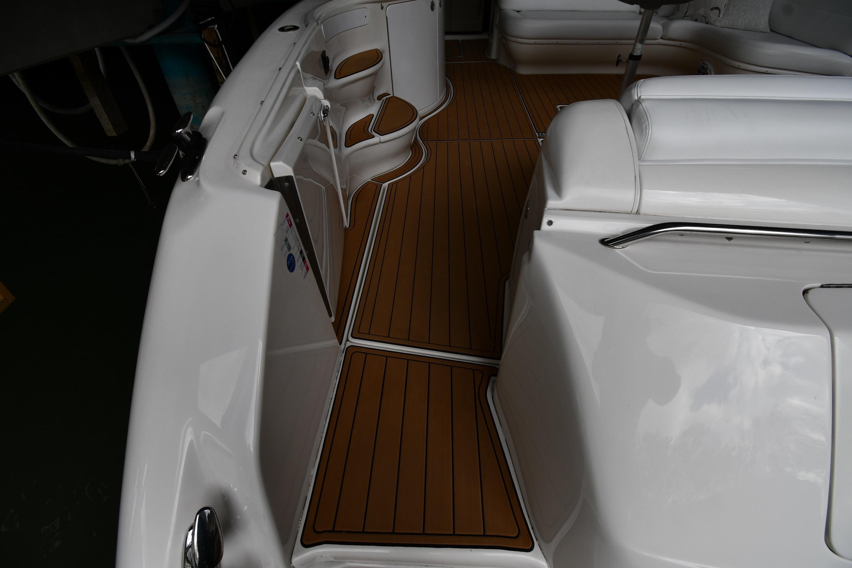 2001 Sea Ray 540 Sundancer boat interior with sleek white seating and wood-style flooring.