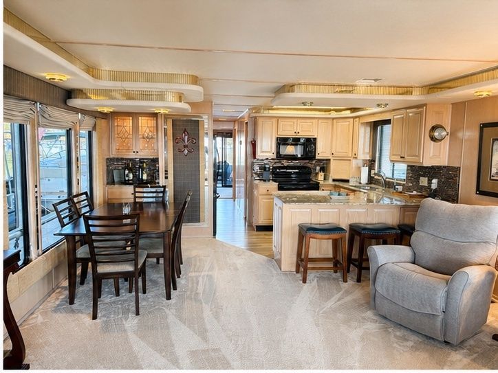 Interior of a 1997 Stardust Cruisers Wide Body with dining area, kitchen, and cozy recliner.