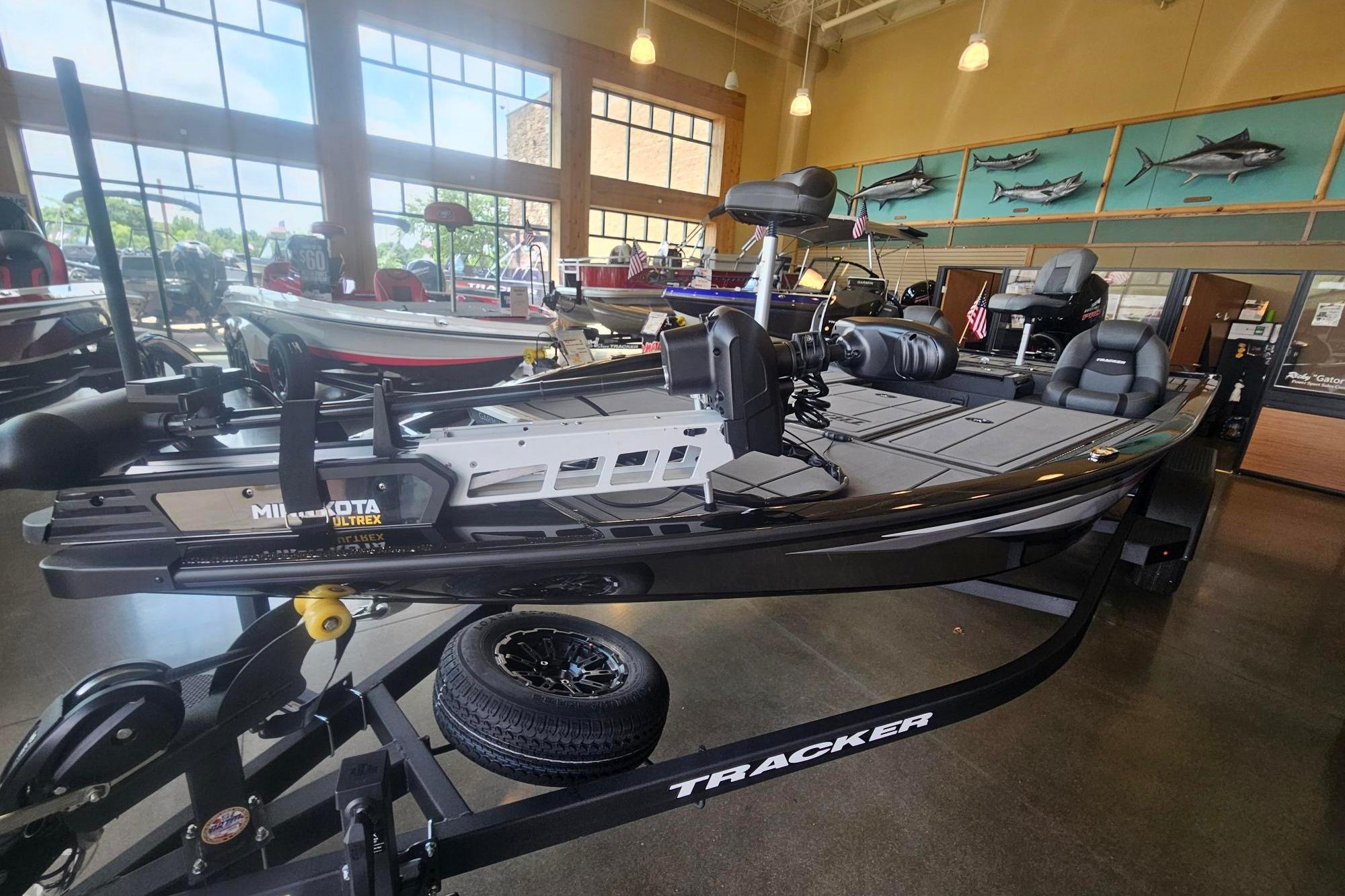 2026 Tracker Savage 215 boat displayed in showroom with fishing equipment.