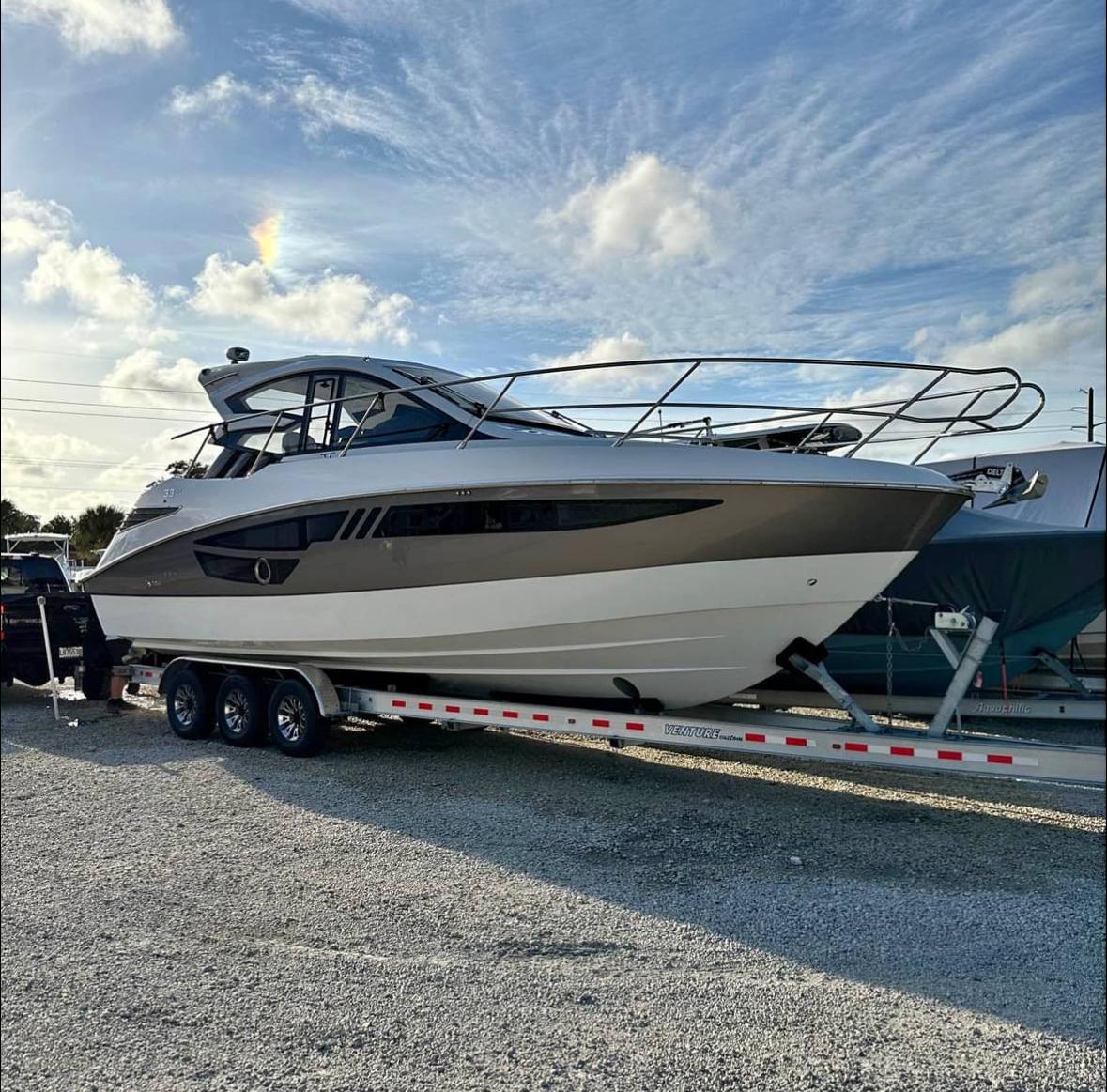 2021 Cobrey 33 HT yacht on trailer under a blue sky.