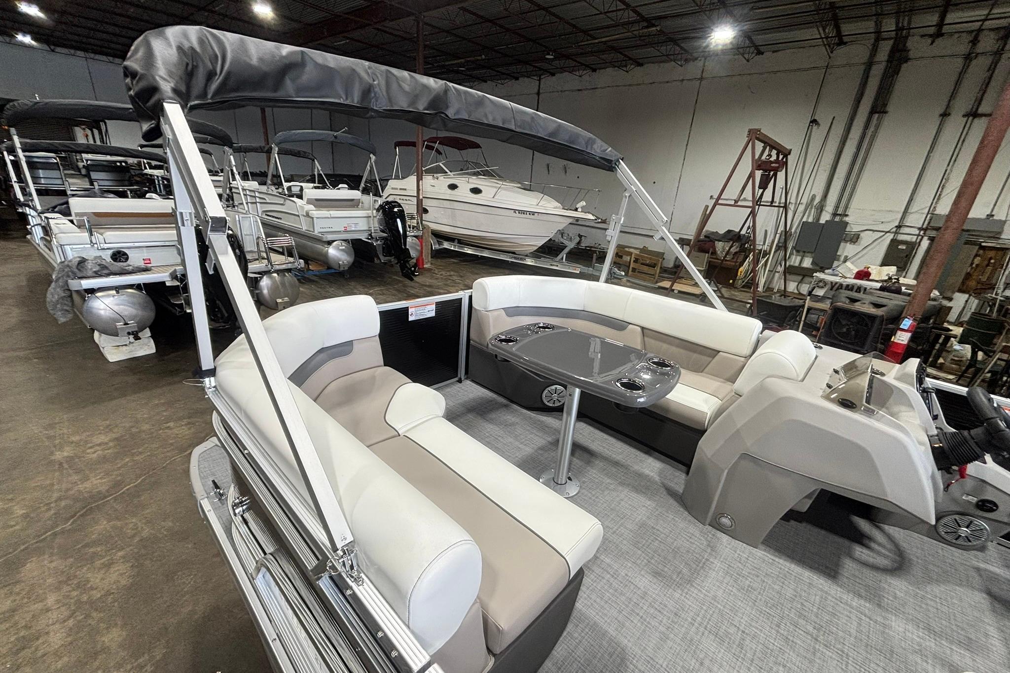 2025 Princecraft Vectra 21 RL pontoon boat with spacious seating in a showroom.