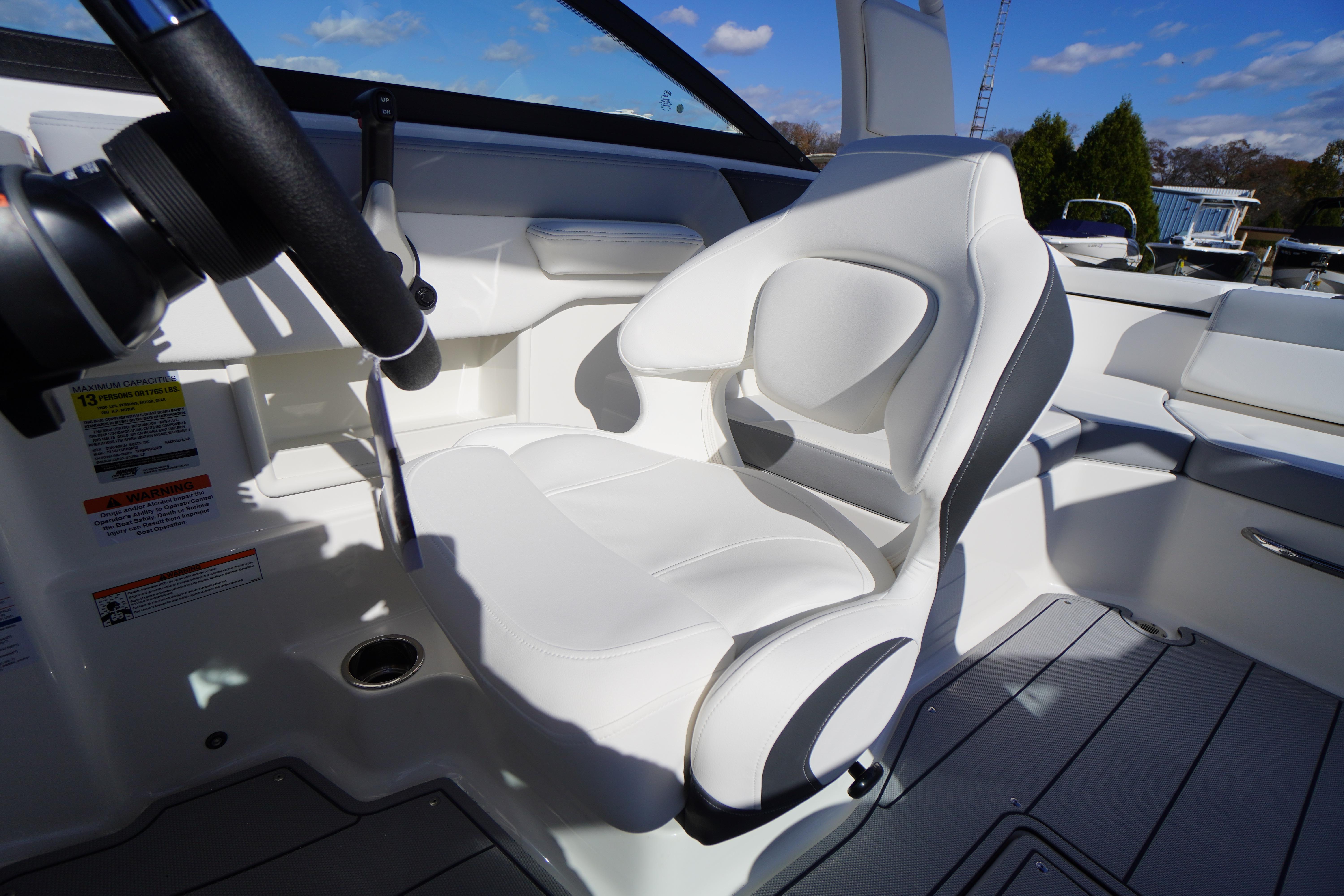 2026 Chaparral 23 SSi OB boat interior with white captain's seat and steering wheel.