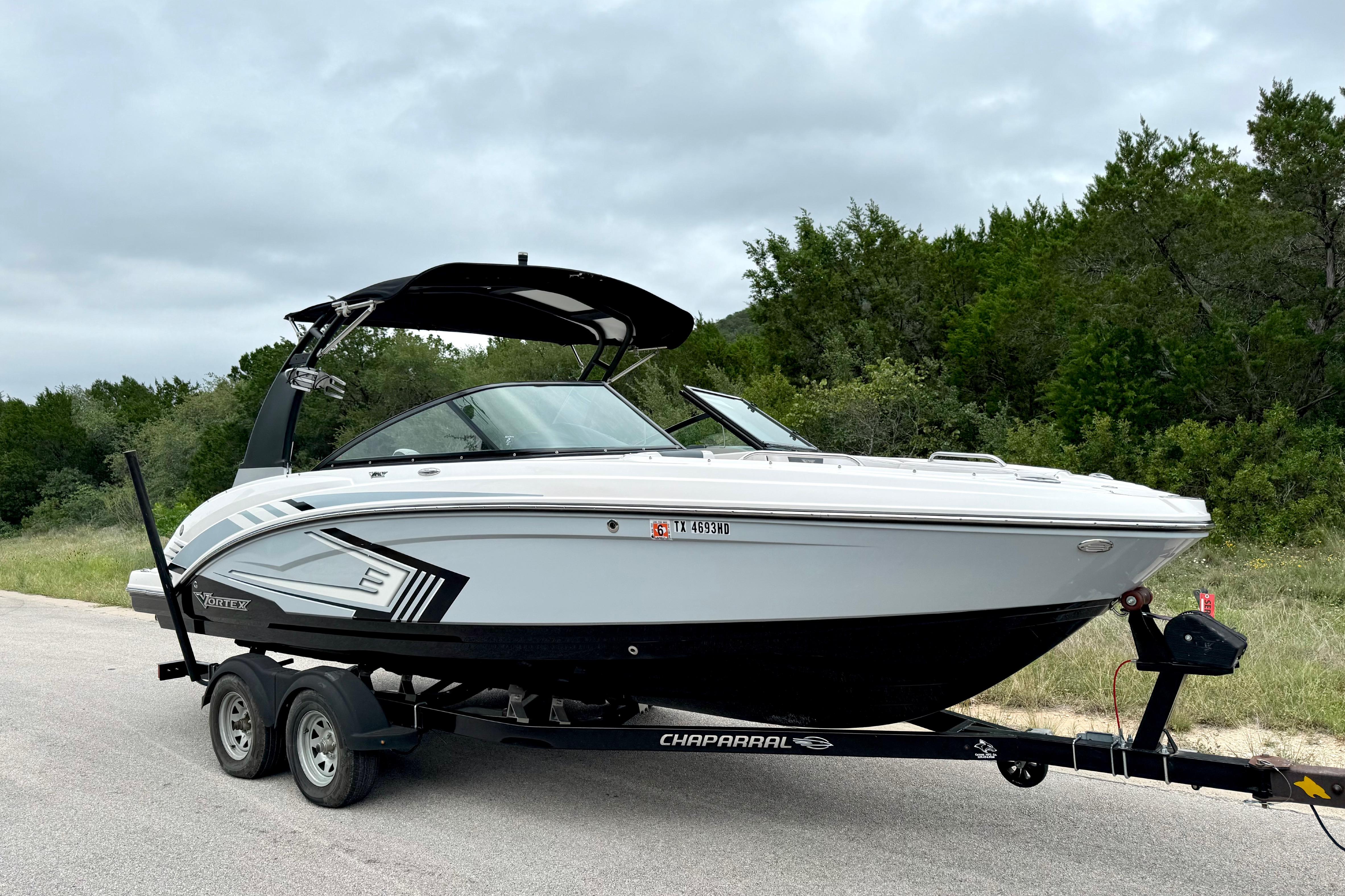 2019 Chaparral Vortex 223 VRX boat on trailer, parked on roadside with trees in background.