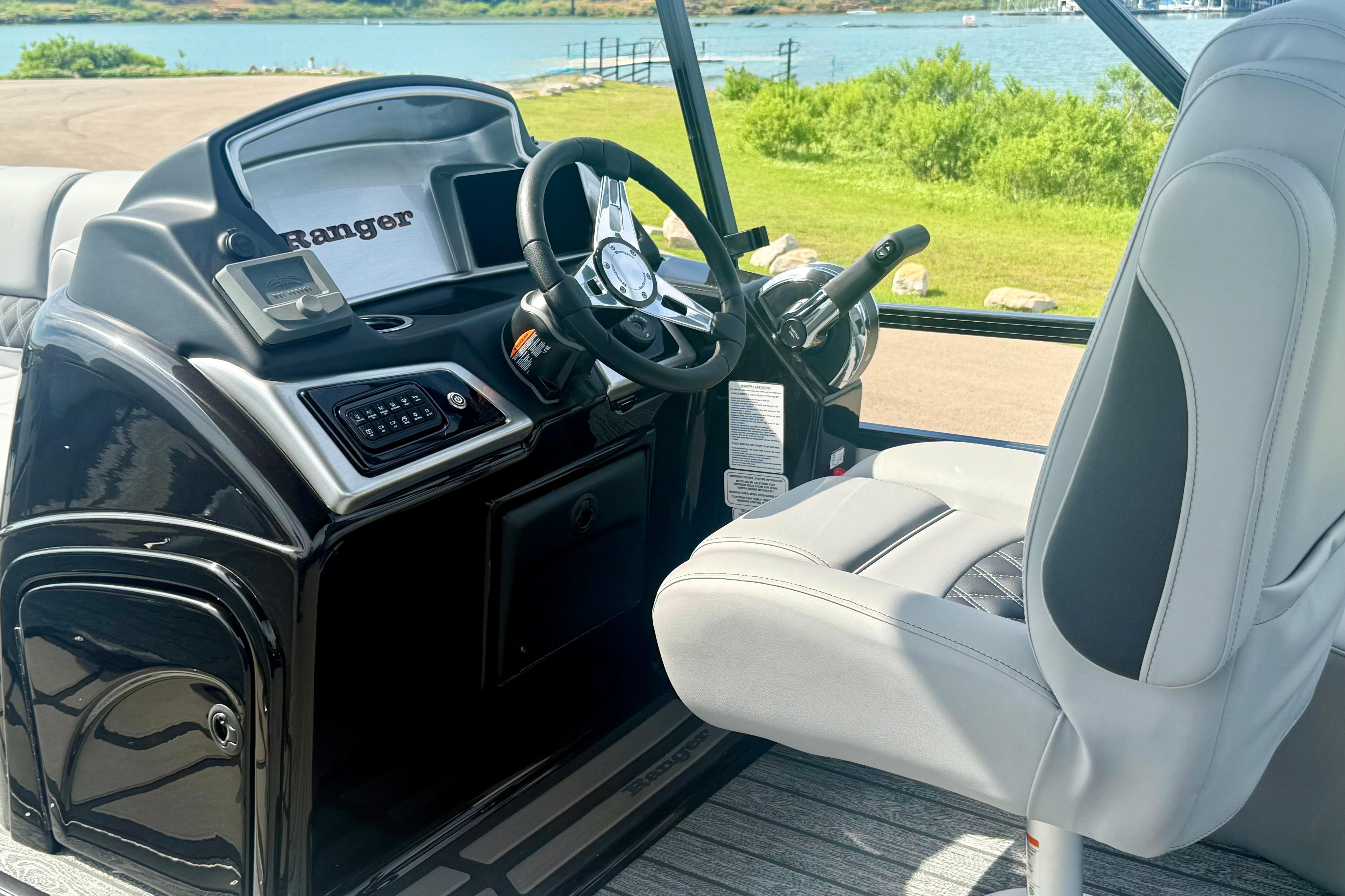 Interior of 2026 Ranger 223FC boat with steering wheel and captain's chair.
