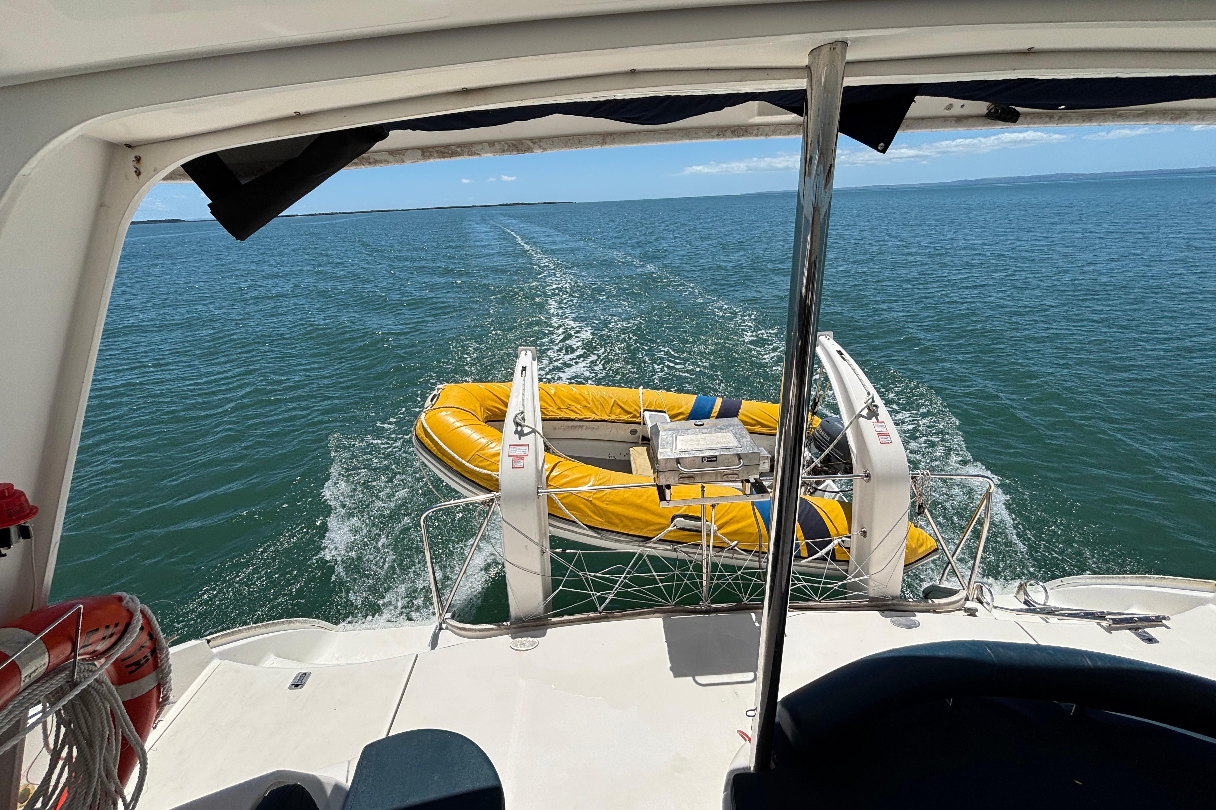 Leopard 40 catamaran towing a yellow dinghy on open water, 2007 model.
