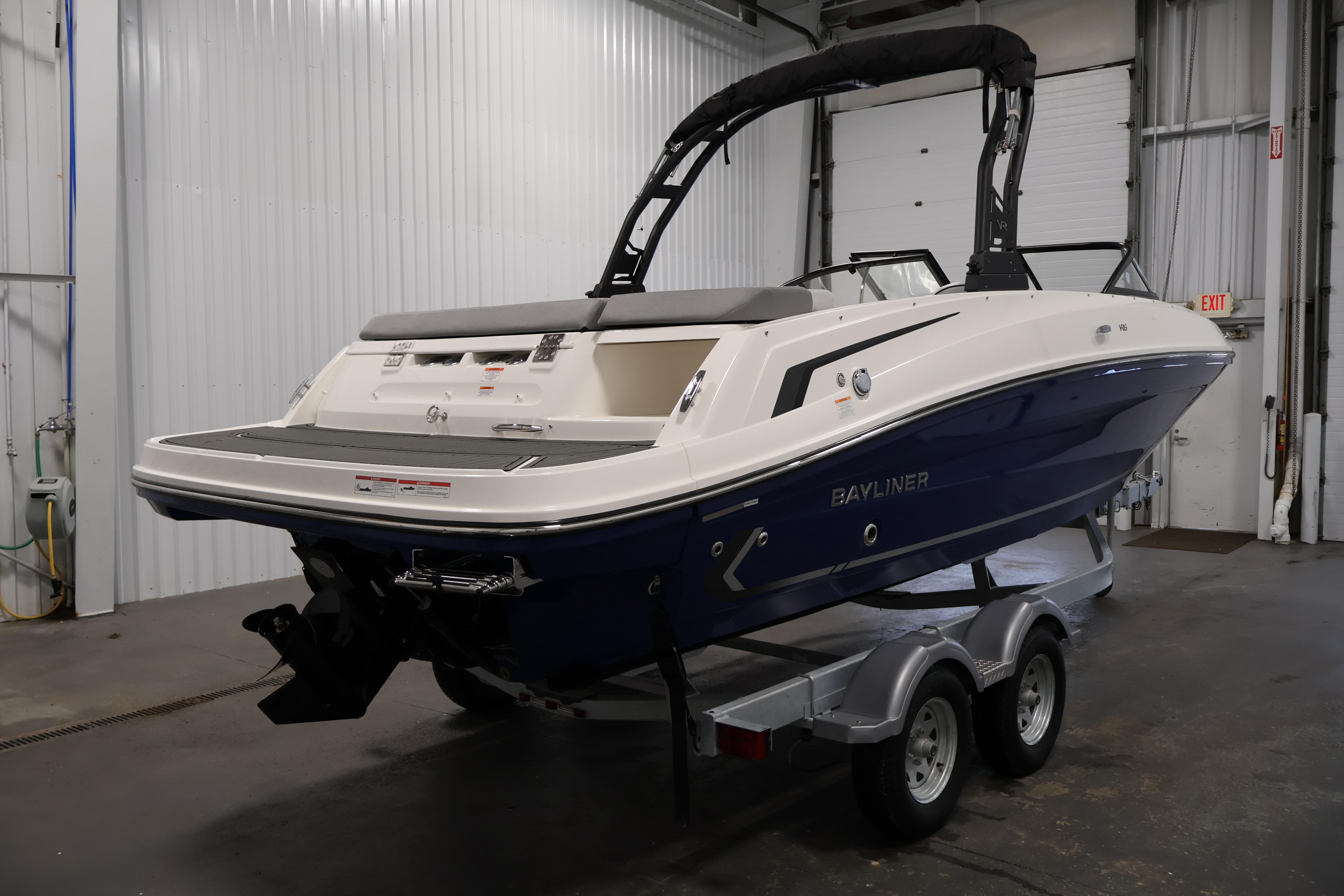 2026 Bayliner VR6 Bowrider I/O boat on trailer in indoor storage facility.