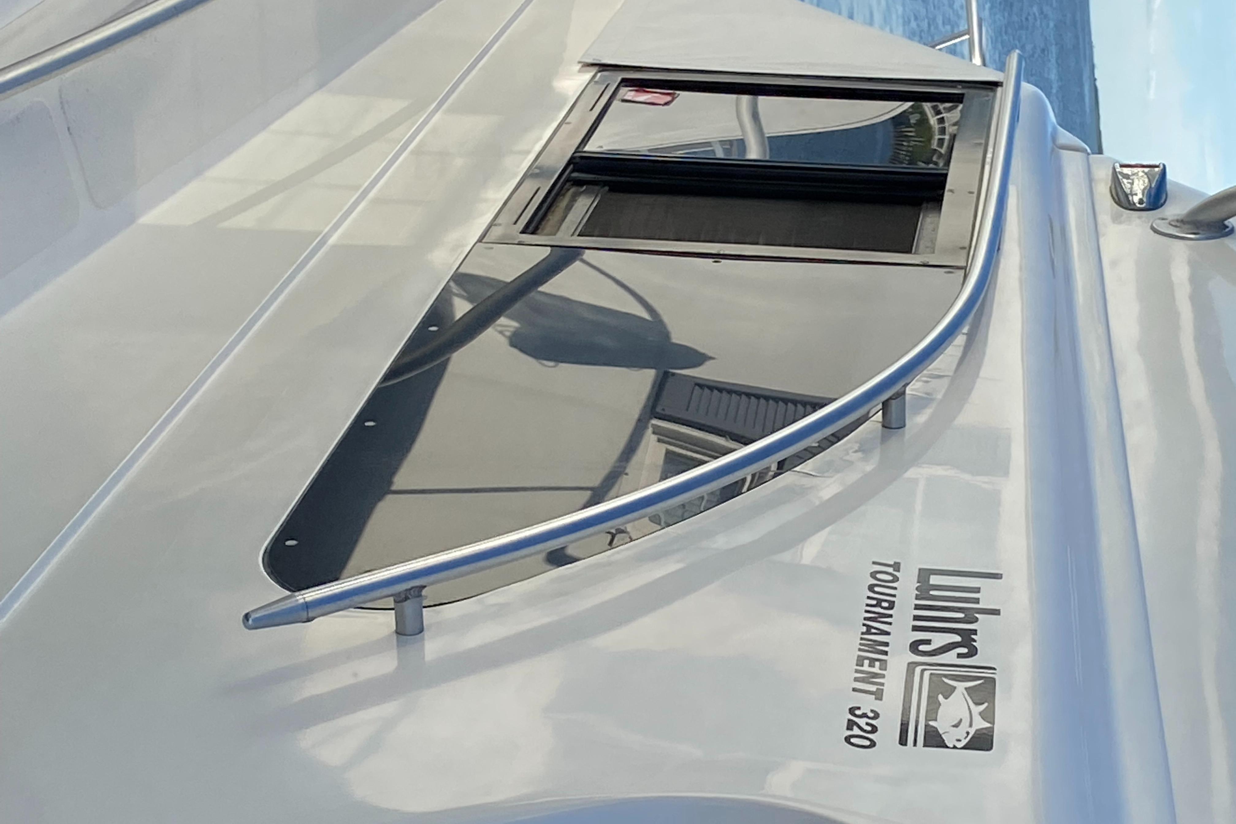 1992 Luhrs Tournament 320 Convertible boat deck with window and railing.