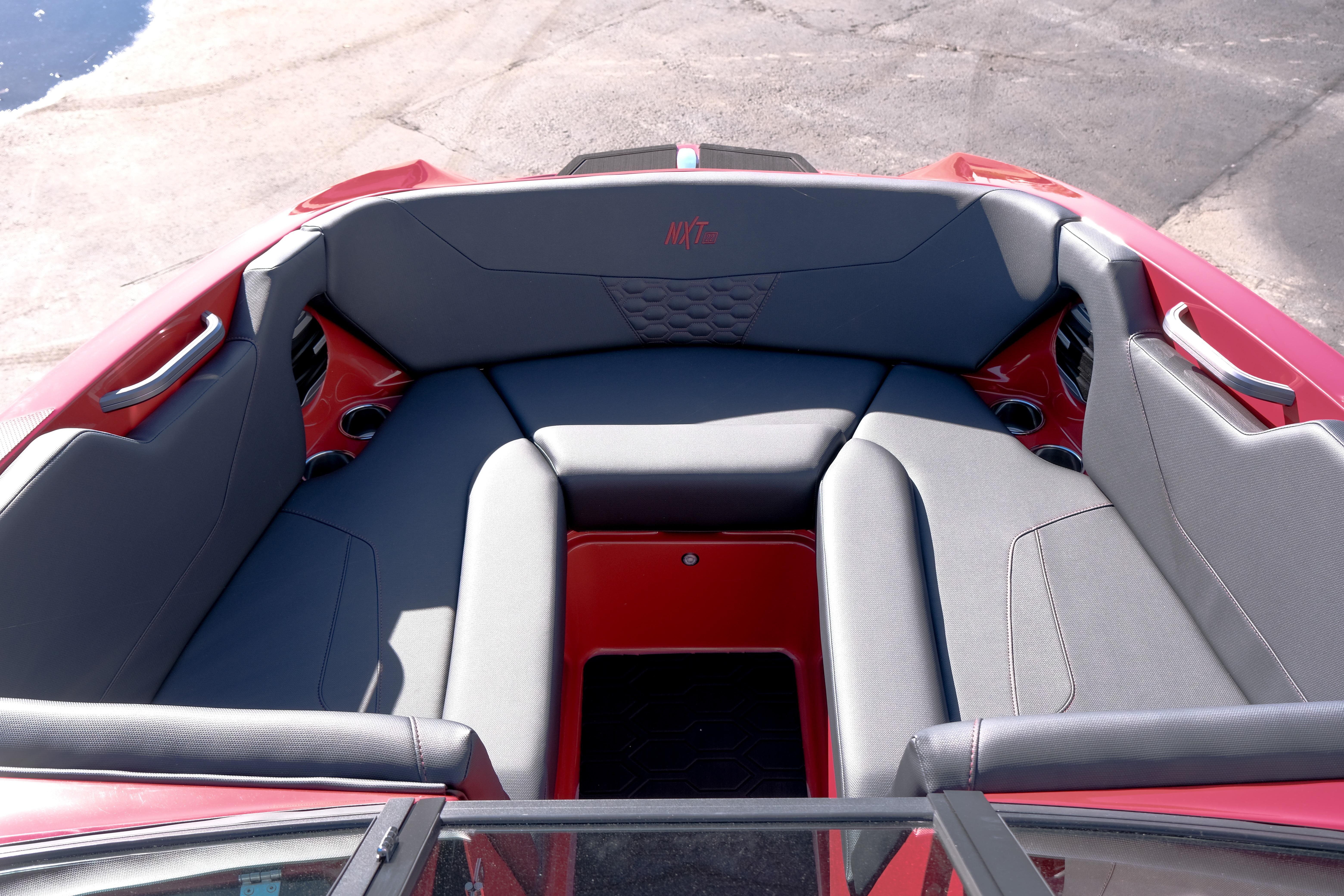 2026 MasterCraft NXT22 boat interior with gray seating and red accents.