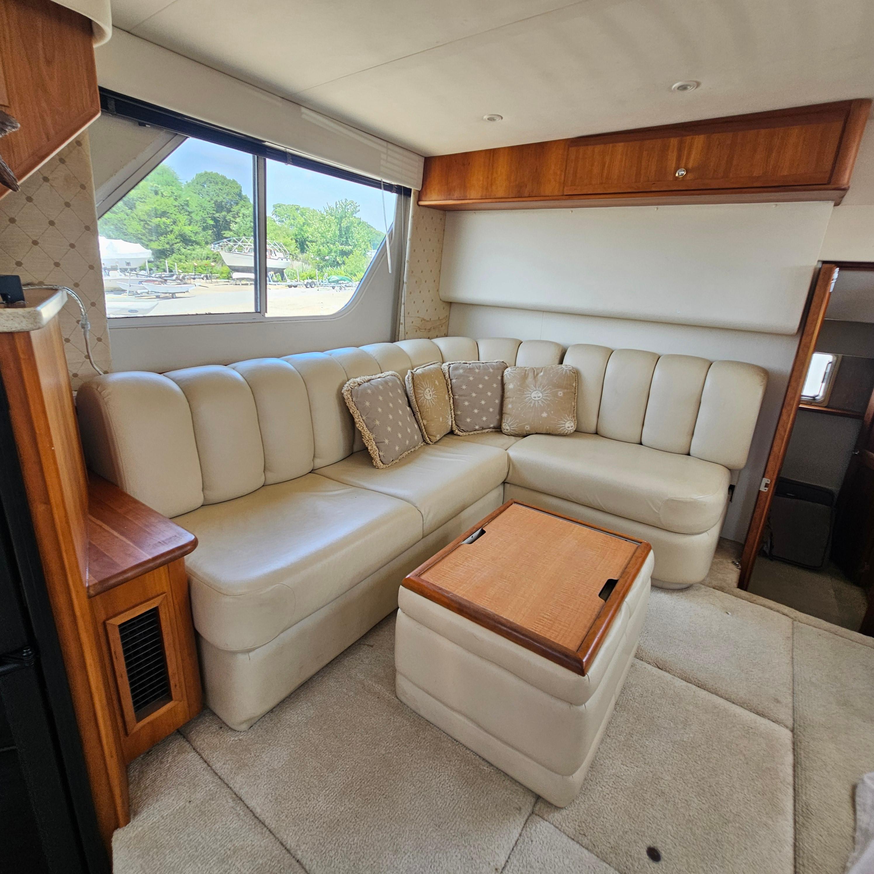Interior of 2000 Silverton 392 Motor Yacht with cream leather seating and wooden accents.