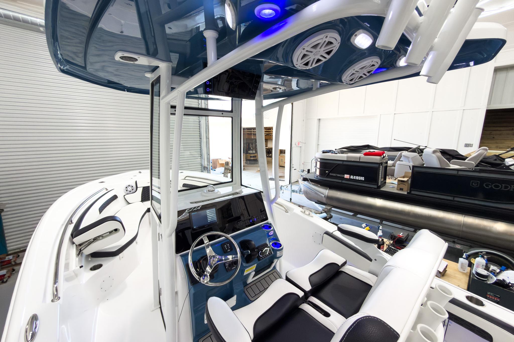 The image shows the cockpit of a modern boat with blue accents and white seating.