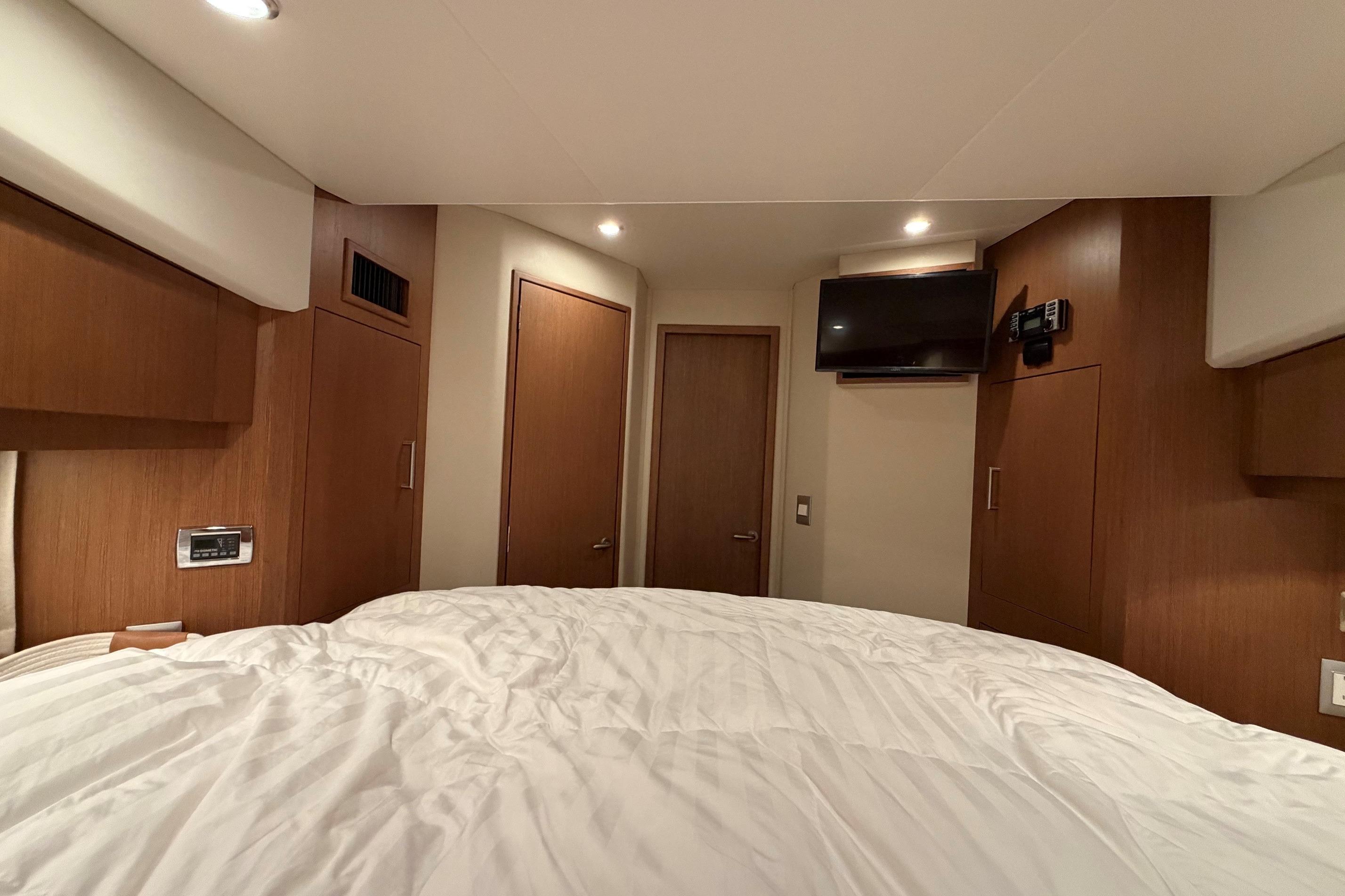 Interior cabin of 2011 Carver 44 Sojourn yacht with wood paneling and mounted TV.