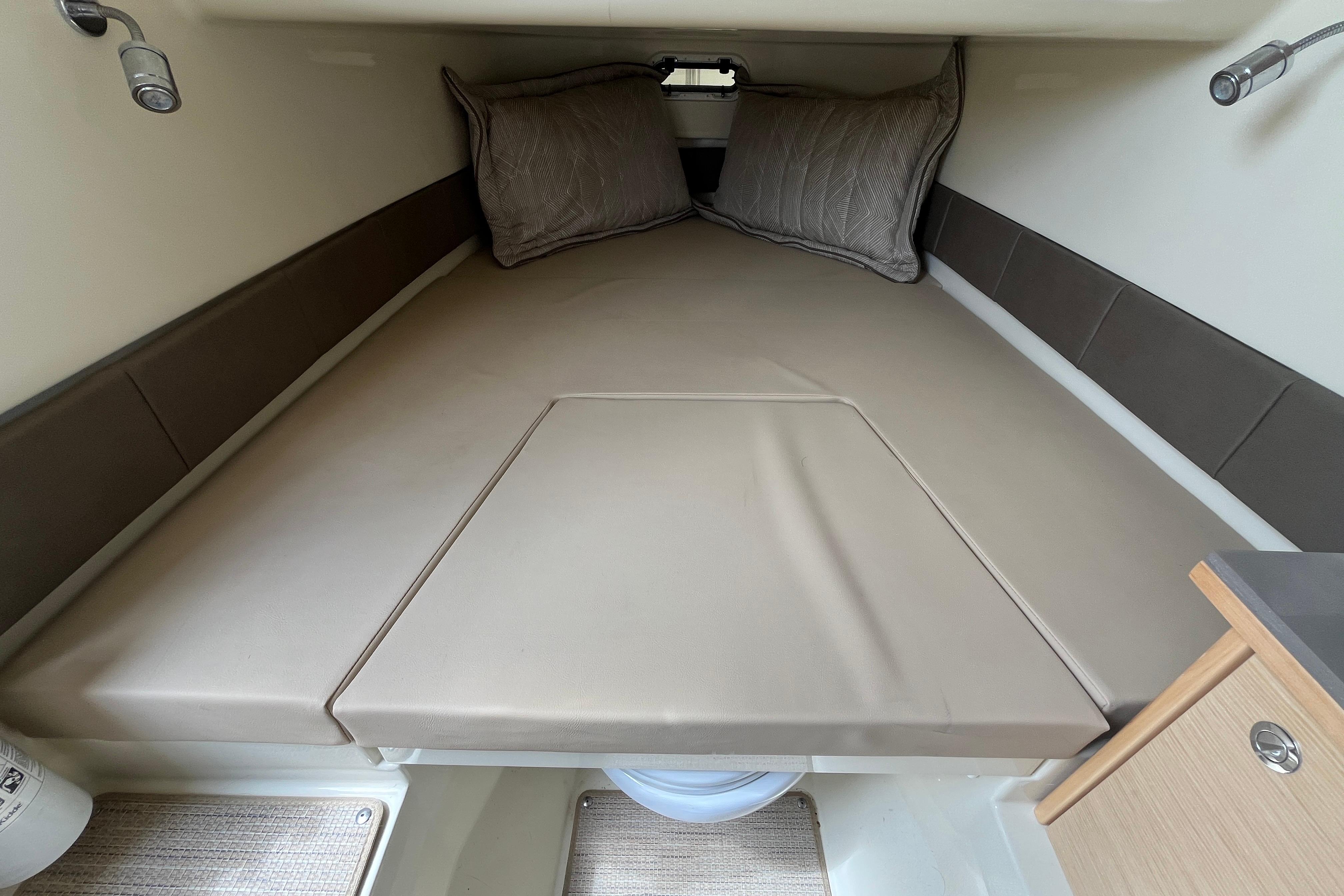 2024 Chris-Craft Catalina 30 cabin interior with cozy bed and pillows.