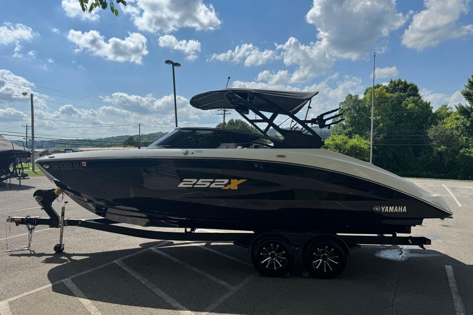 2023 Yamaha Boats 252XE on trailer under blue sky, parked in lot.