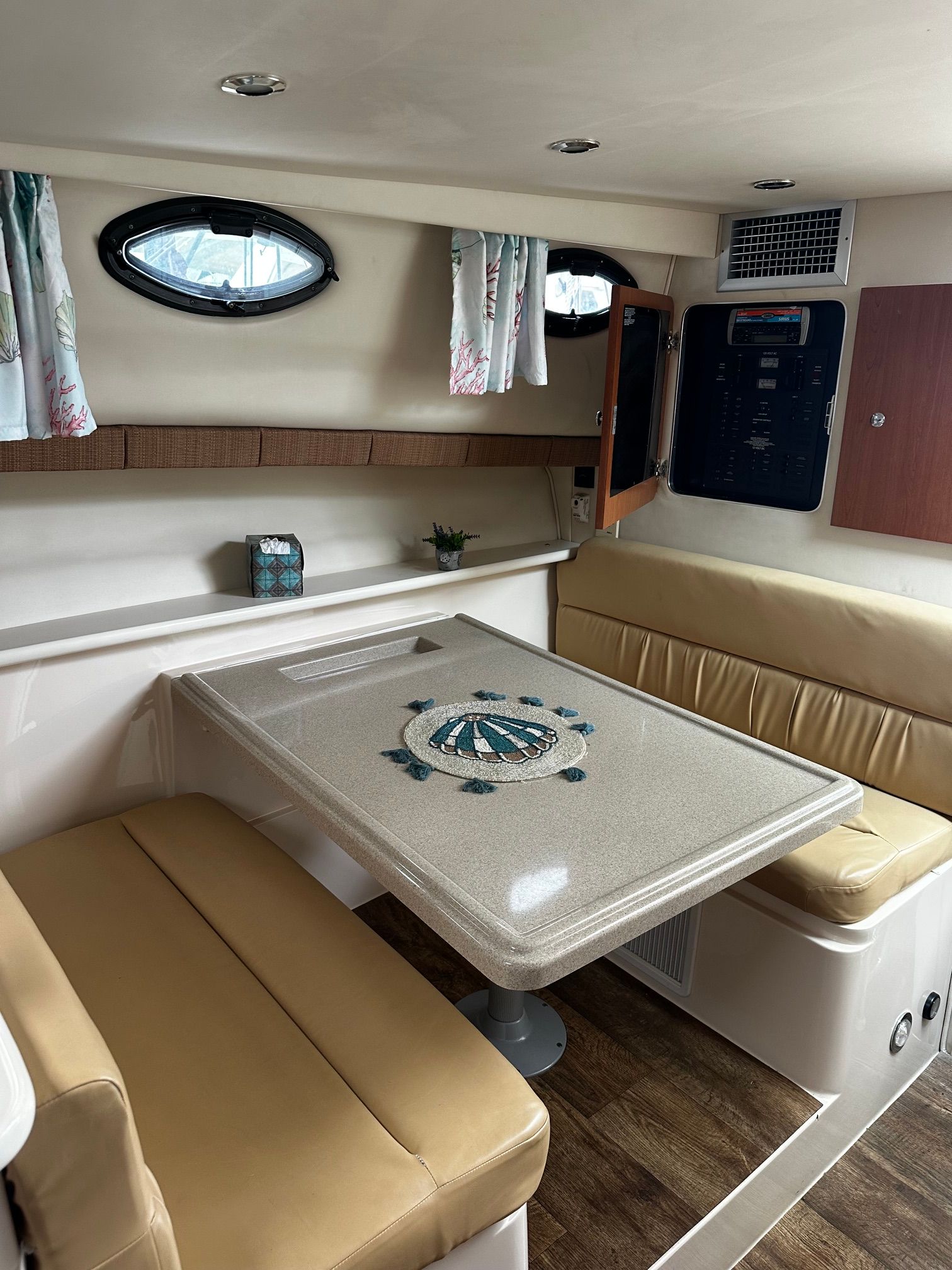 Interior of a Wellcraft 330 Coastal with beige sofa and table.