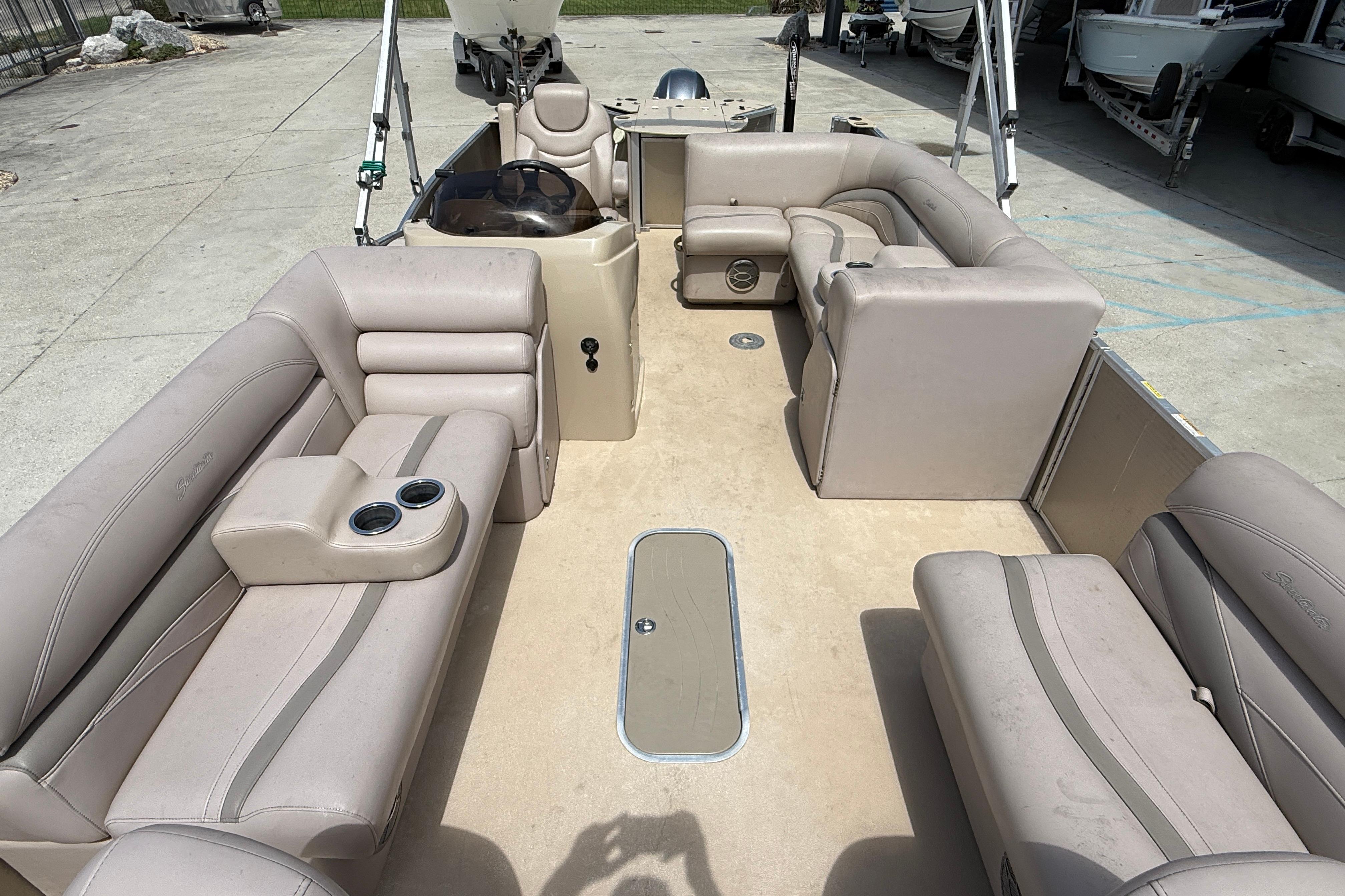 2014 Godfrey Sweetwater 2486 C pontoon boat with beige seating and cup holders.