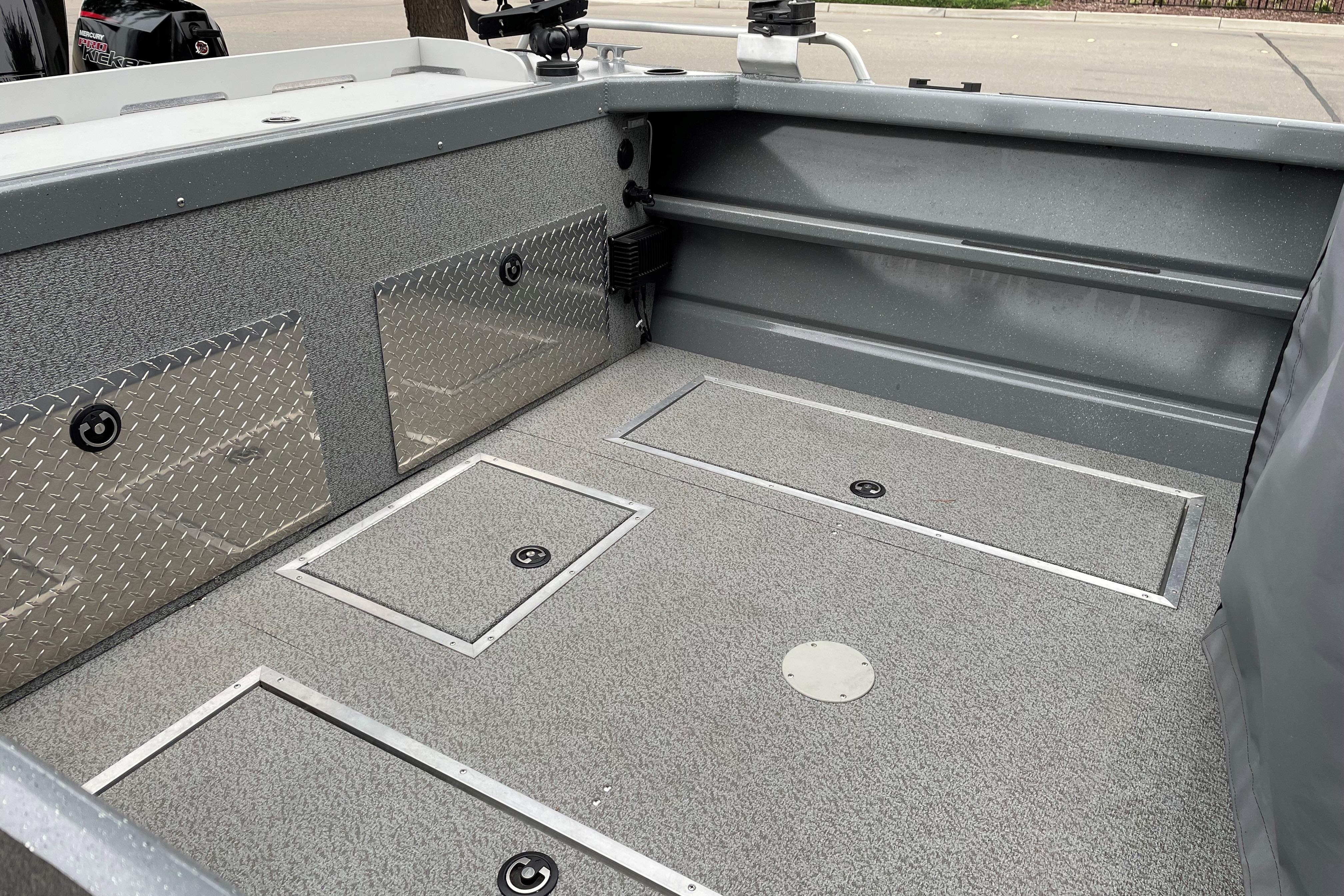 2024 Spartan 200 Astoria boat interior with storage compartments and diamond plate accents.