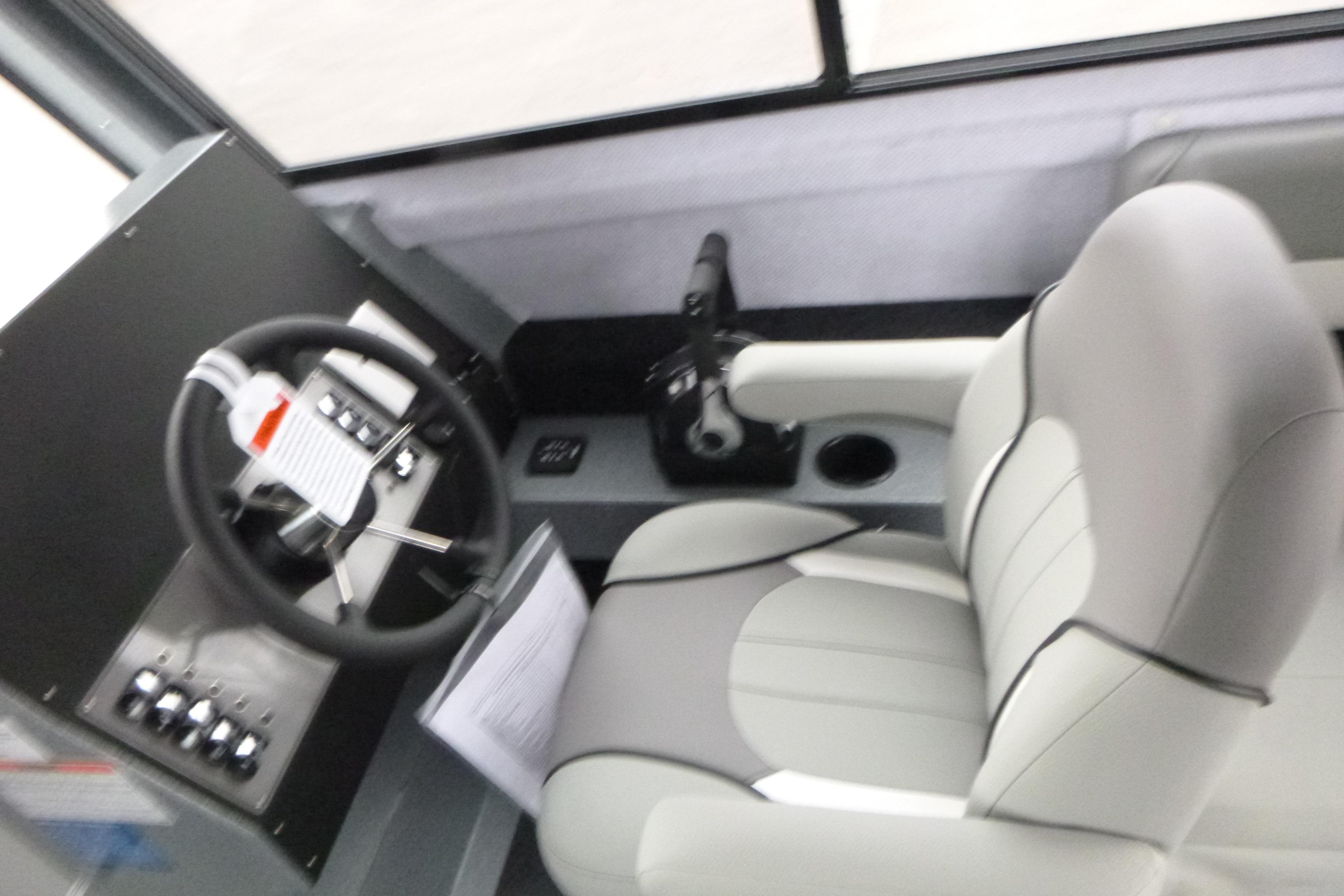 Interior cockpit of 2026 KingFisher 25 XAC boat with steering wheel and controls.