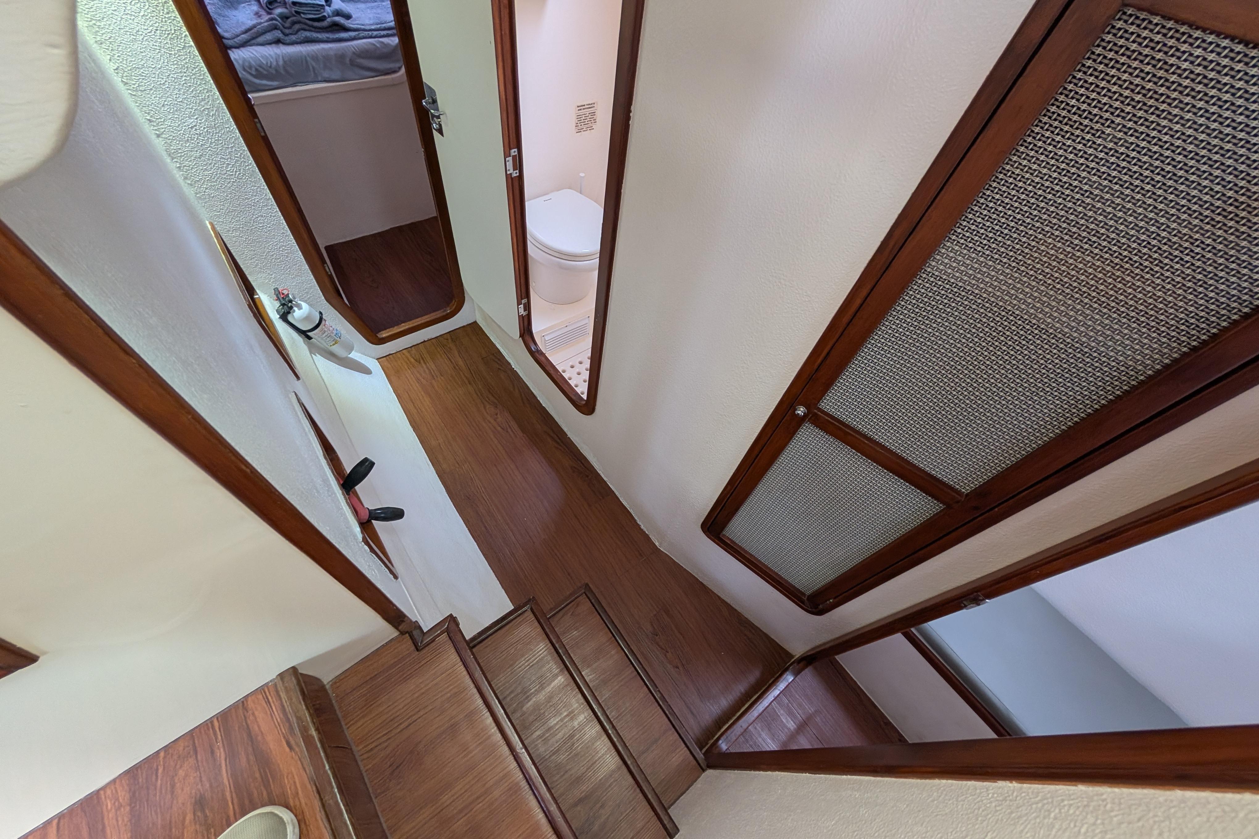Interior view of 1999 Island Spirit 37 yacht, featuring wooden stairs and cabin access.