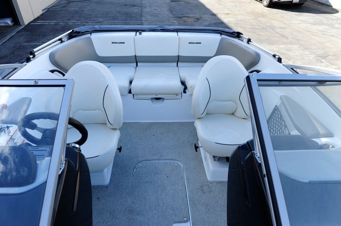 Interior view of a 2011 Custom Challenger 180 boat with white seats and gray carpet.