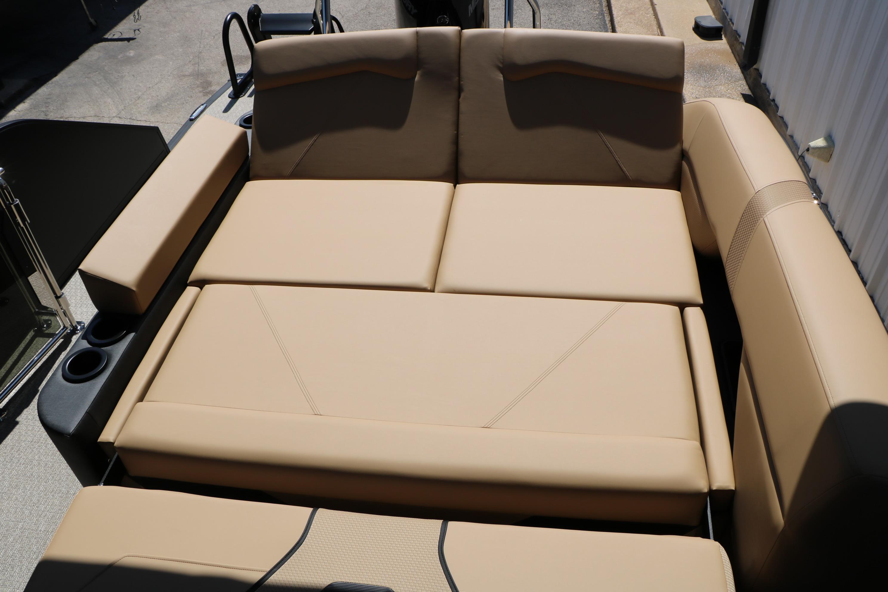 Luxurious seating on 2026 Evotti 725 CS Tri-Toon boat, featuring beige upholstery and cup holders.