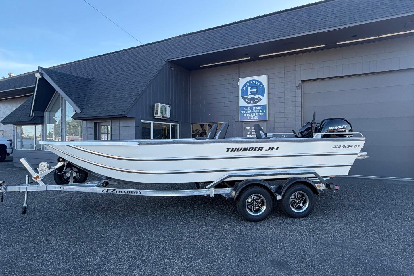 2026 Thunder Jet 209 Rush OT boat on trailer outside a marine service building.