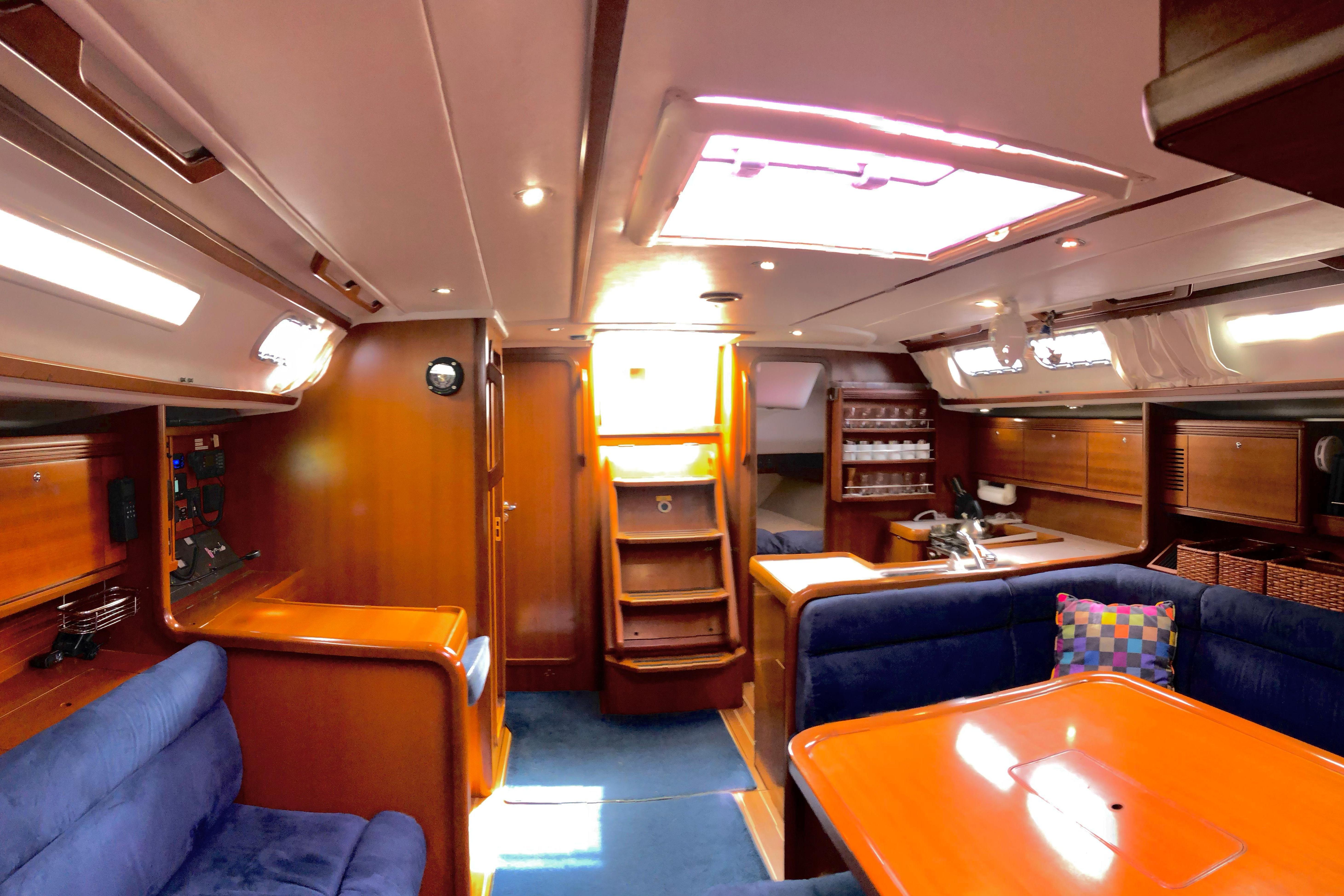 Luxurious interior of a 2006 Grand Soleil 50 yacht with wooden finishes and blue seating.