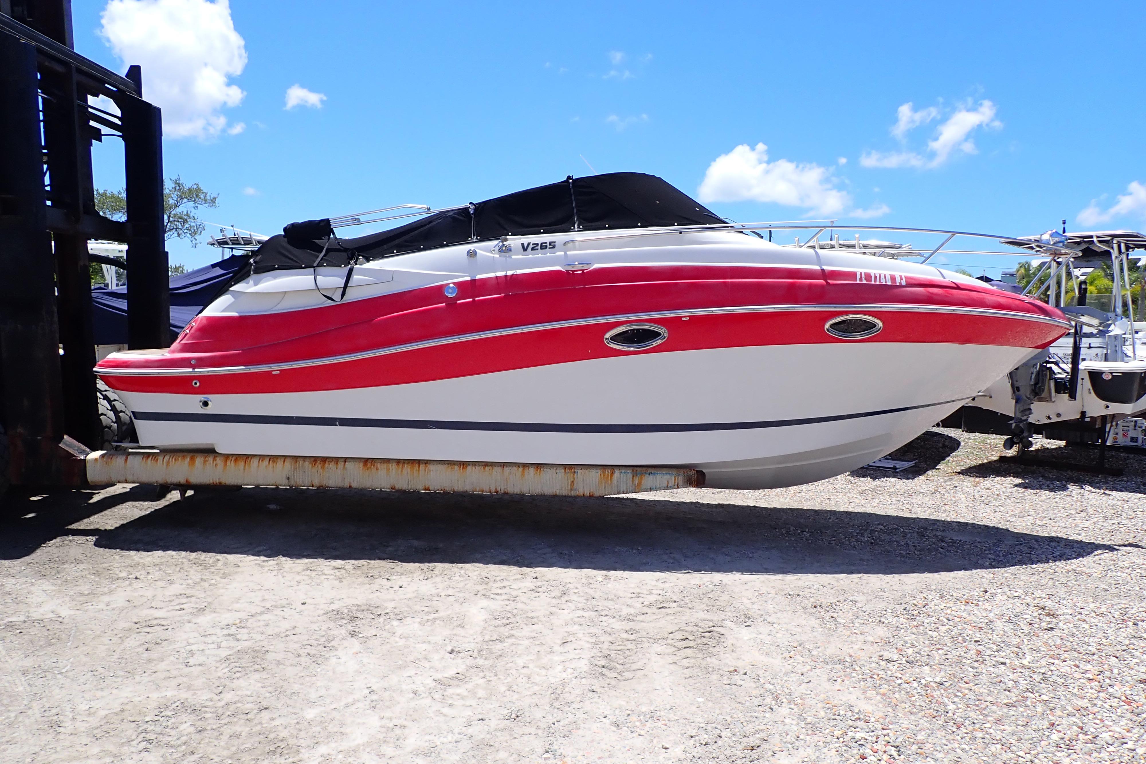 2012 Four Winns V265 boat with red and white design on dry dock.