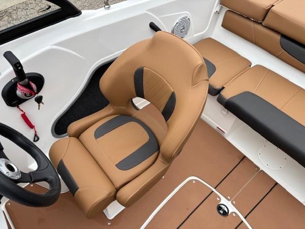 2025 Tahoe 185 S boat interior with tan and black seating, steering wheel, and speaker.