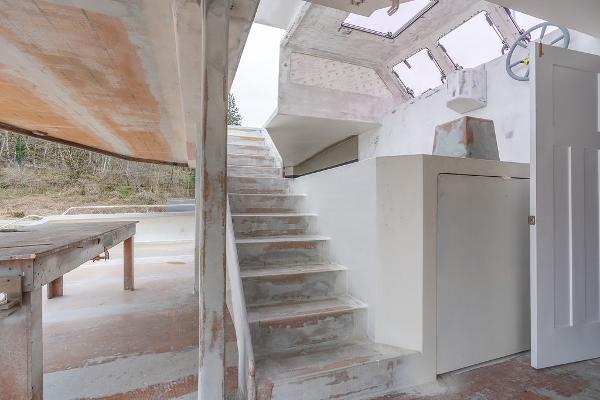 Interior view of 2025 Catamaran Bloomfield 86 Motorsailor under construction, featuring stairs and unfinished surfaces.