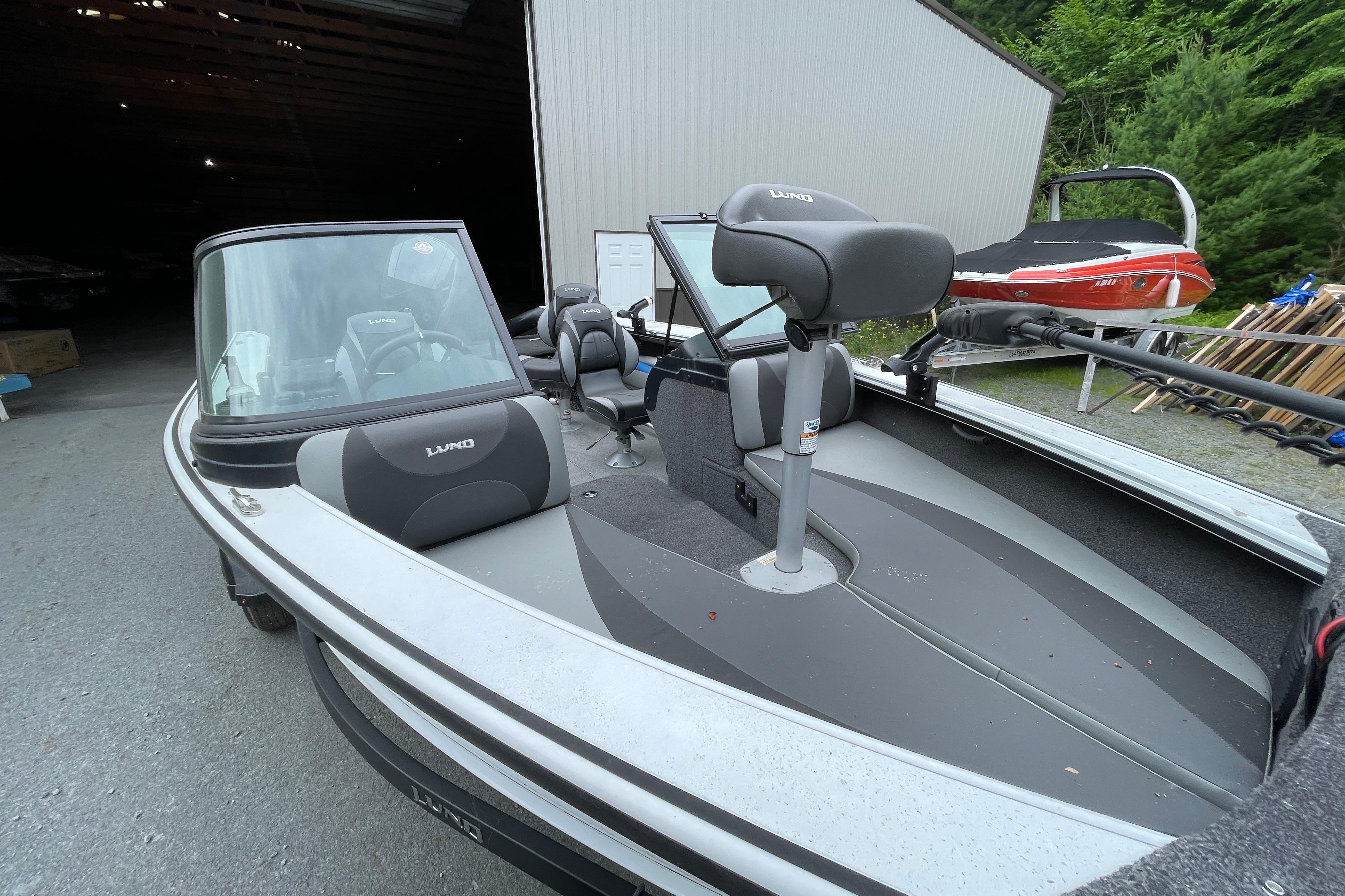 2022 Lund 1875 Crossover XS boat parked outside a storage building.