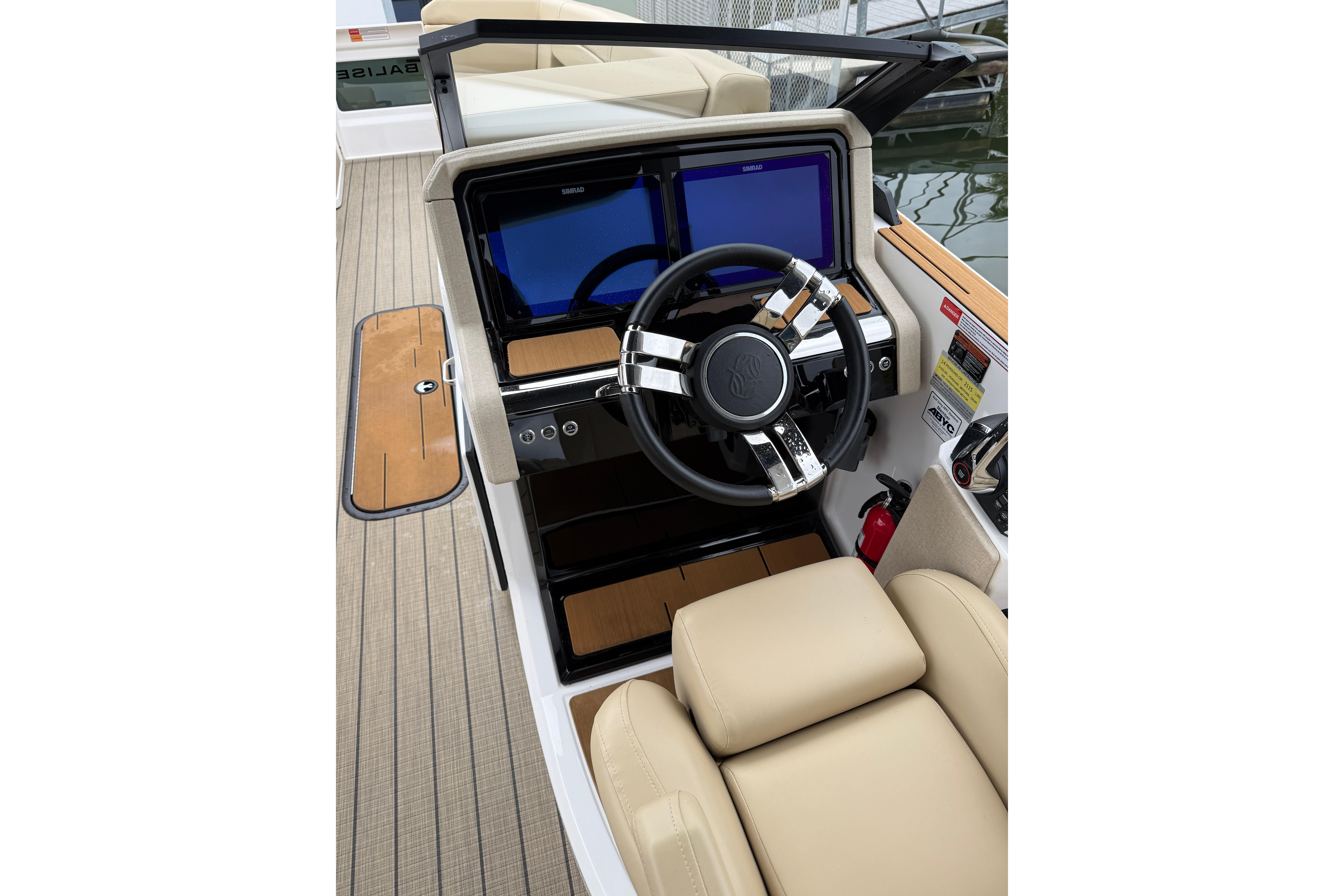 Helm of 2025 Balise Helix 26 L boat with modern steering and dual screens.