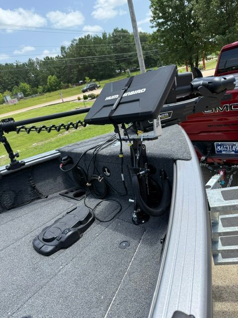 The image shows the deck of a Lund 2075 Impact XS boat with a fish finder and rod holder.