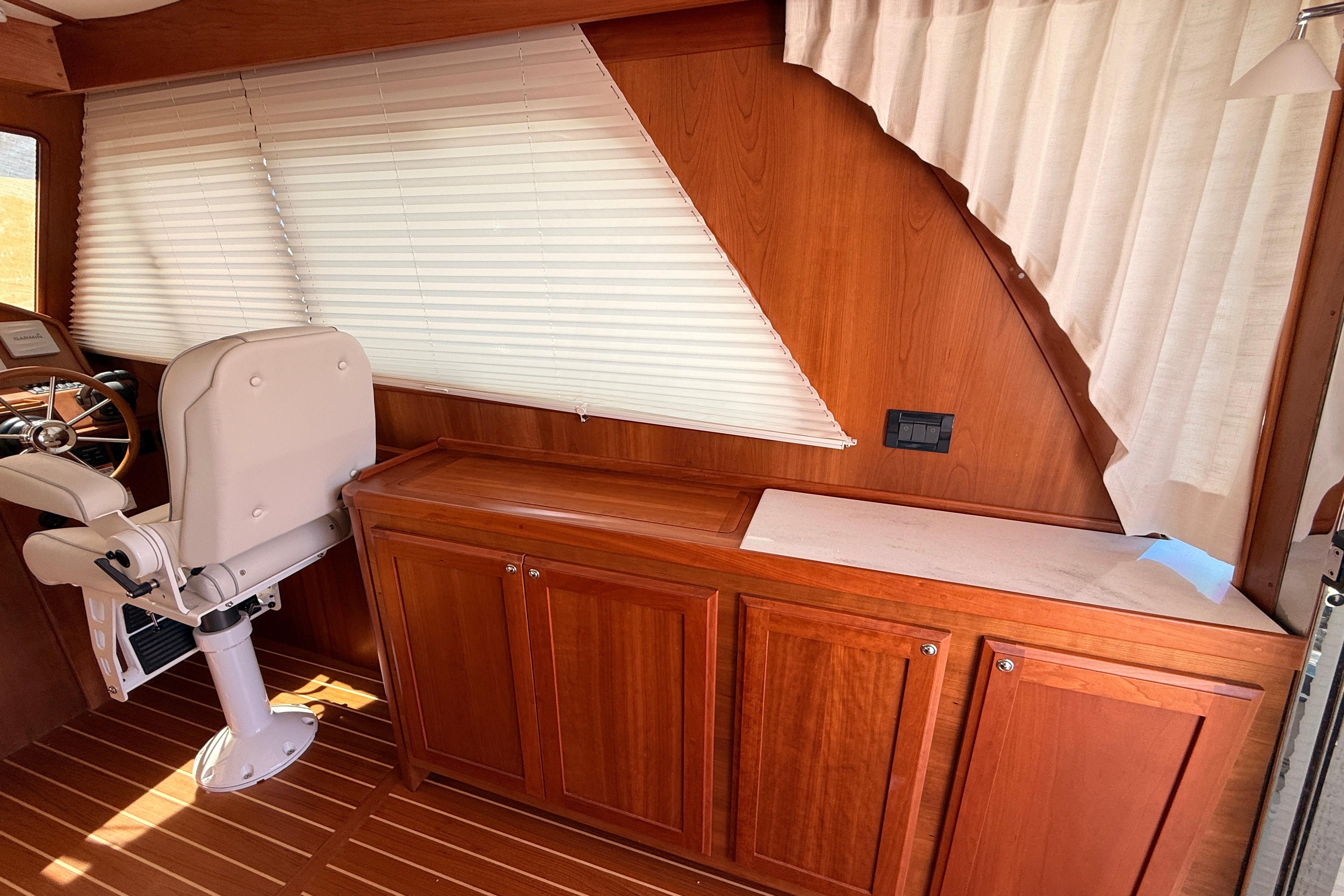 Interior of 2022 Sabre 38 Salon Express with wooden cabinetry and helm seat.