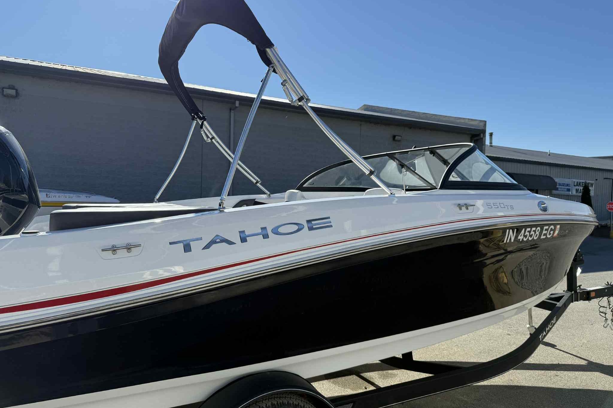 2021 Tahoe 550 TS boat on trailer, black and white design, parked outdoors.