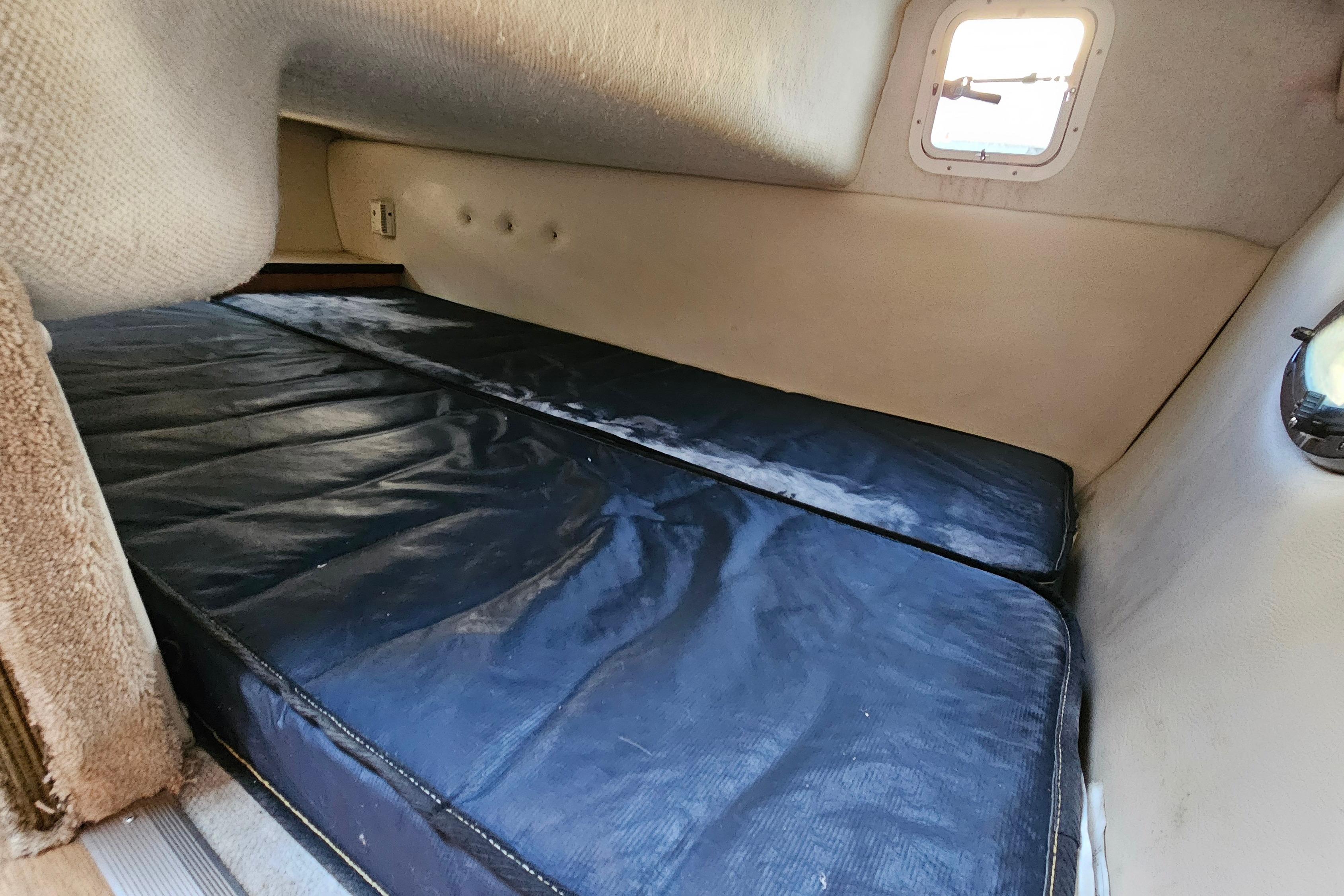 Interior cabin of 1999 Regal Commodore 258 boat with cushioned sleeping area.