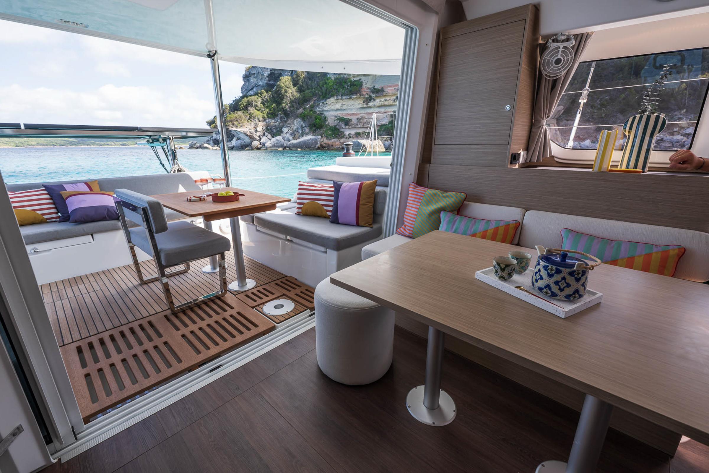 Interior of 2025 Lagoon 38 catamaran with cozy seating and ocean view.